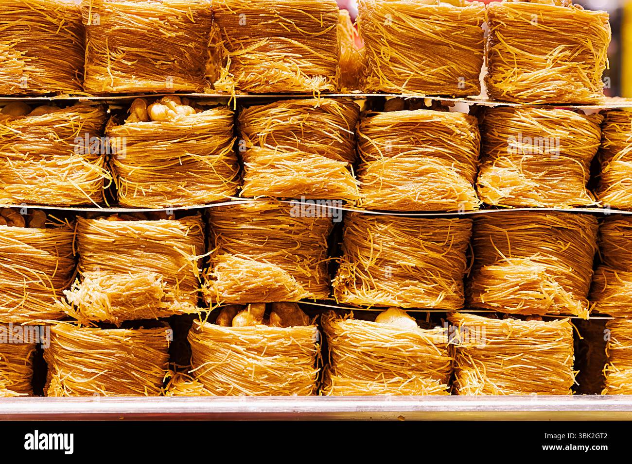 Nahaufnahme von süßen Desserts aus dem Nahen Osten, die aus geriebenem Kataifi-Teig zubereitet und mit Nüssen gefüllt wurden. Golden und knusprig, beliebt in türkischen und arabischen Cuis Stockfoto