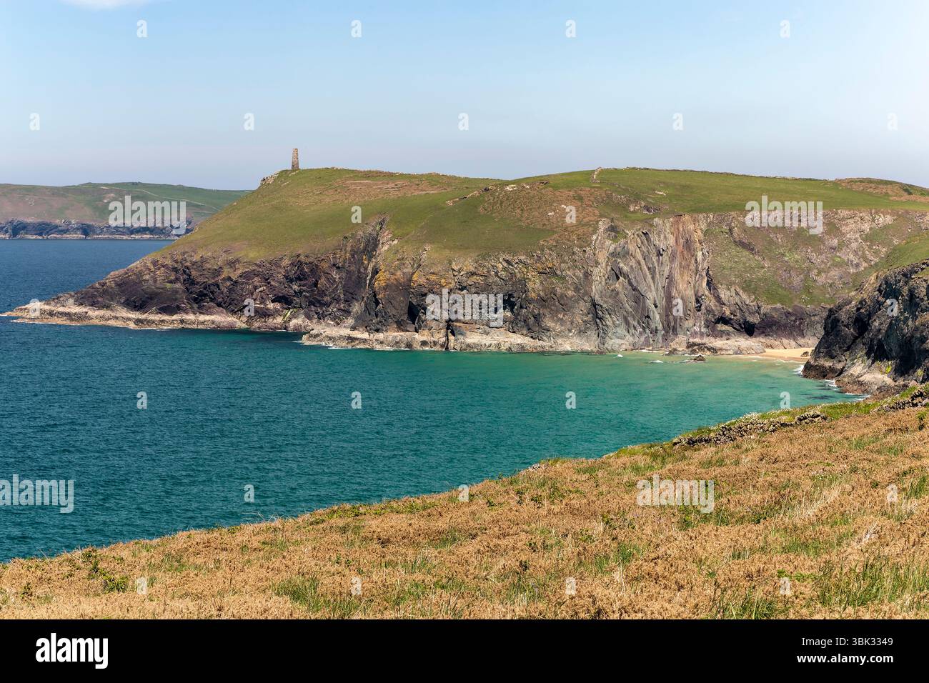 Farbenfroher Blick auf die Küste von Cornish im Sommer, Blick nach Norden über die Butter Hole Bay, in Richtung Stepper Point, Tower und Headland, mit Cliff und Küstenlinie. Stockfoto