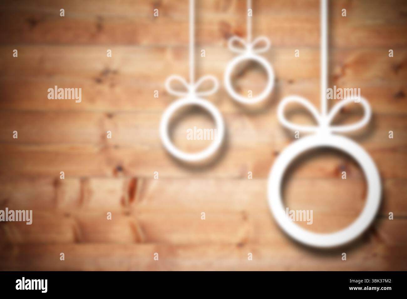 Eine Gruppe von drei weißen Ringornamenten mit Schleife hängt in flacher Form an einer Holzwand Stockfoto