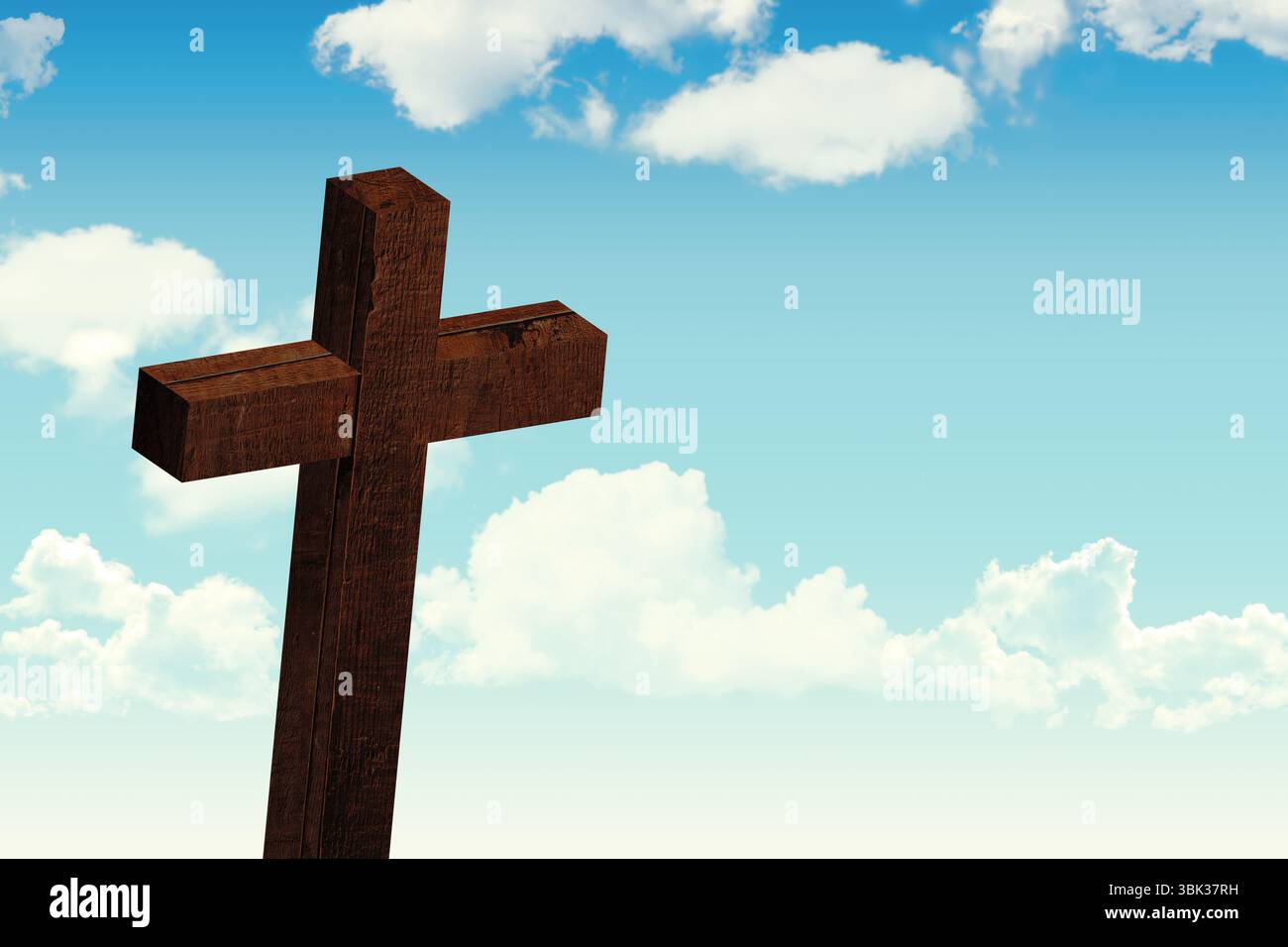 Dunkelbraunes Holzkreuz steht in flacher Form und zeigt sichtbare Holzmaserung und weiße Wolken Stockfoto