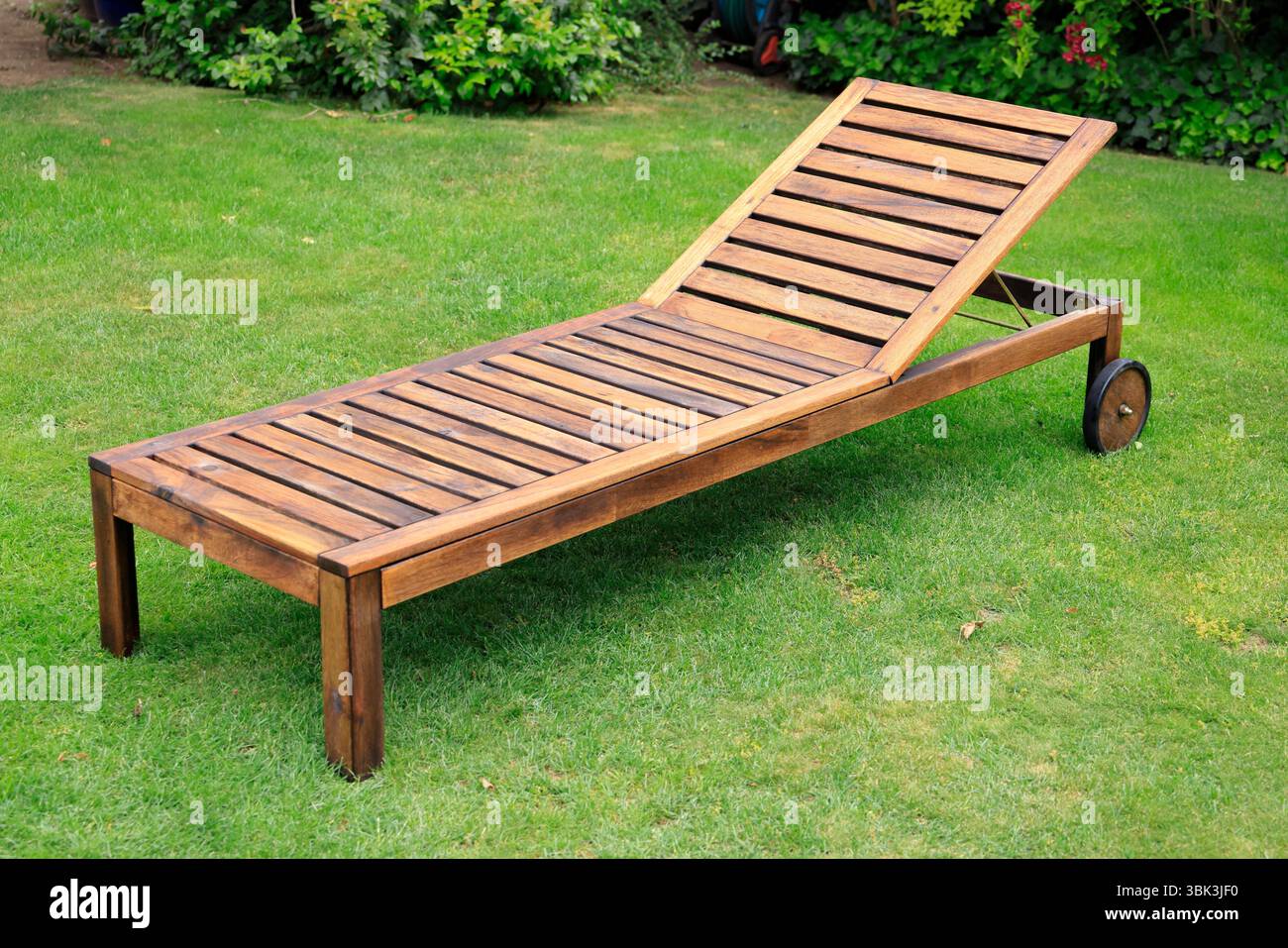 Gepflegte Holzgartenmöbel in einer ruhigen Ecke des Gartens Stockfoto