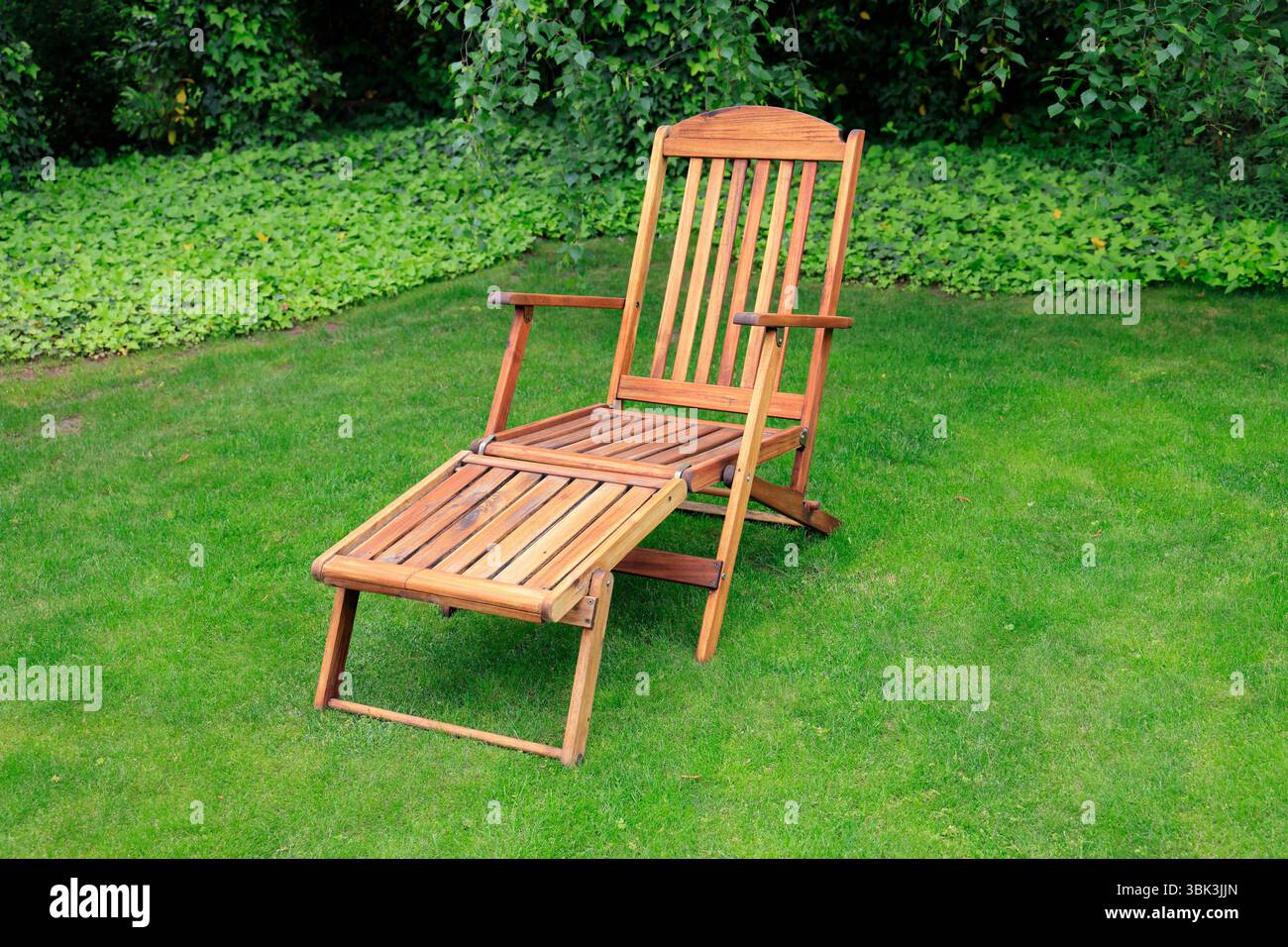 Gepflegte Holzgartenmöbel in einer ruhigen Ecke des Gartens Stockfoto