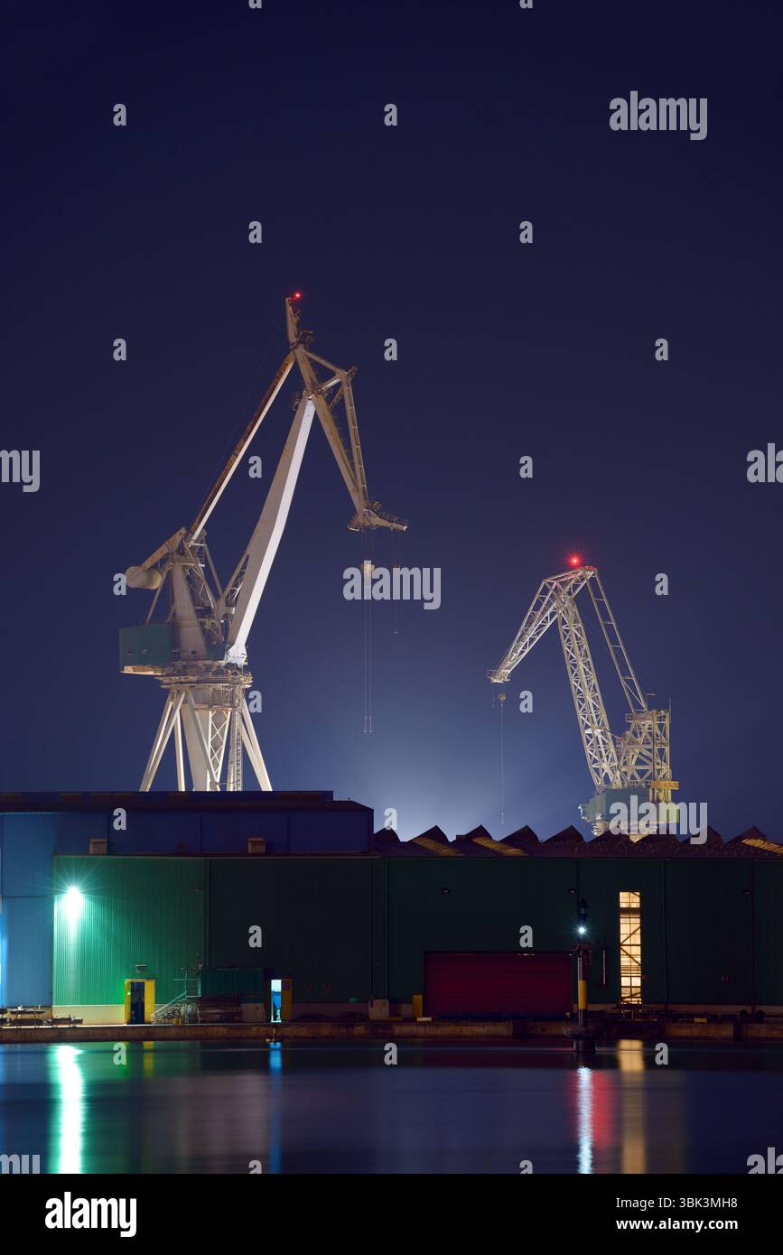 Industrielle Güter Krane auf der Anklagebank bei Sonnenuntergang Stockfoto