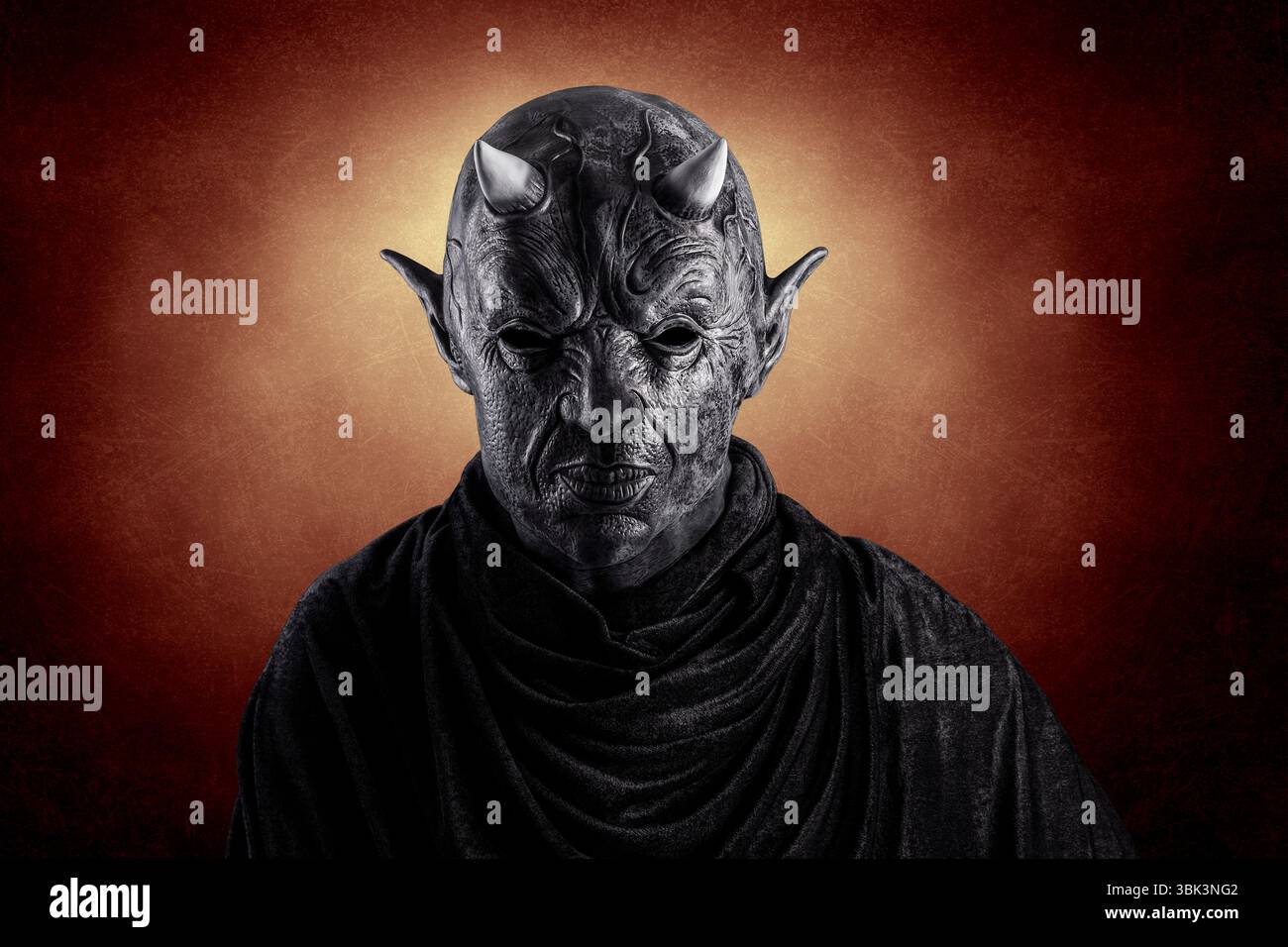 Porträt eines bösen Teufels mit Hörnern auf dem Kopf über dunklem feurigen Hintergrund Stockfoto