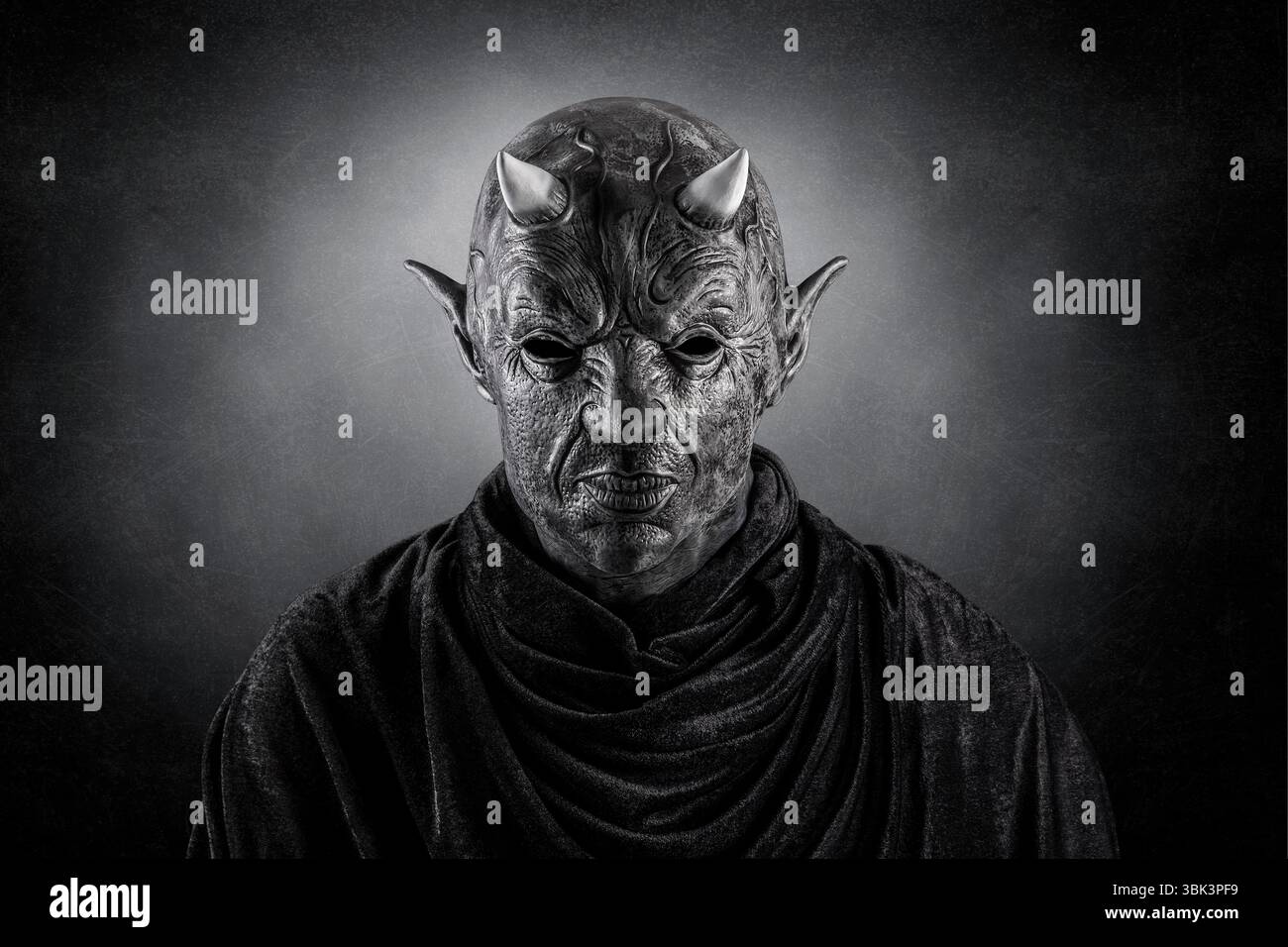 Porträt eines bösen Teufels mit Hörnern auf dem Kopf über dunklem nebeligem Hintergrund Stockfoto