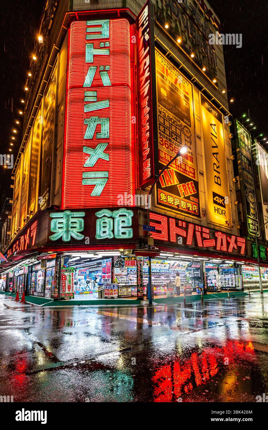 Nasse leere Straße in der Nacht vor dem Yodobashi Camera Store im Stadtteil Shinjuku, Tokio, Japan Stockfoto