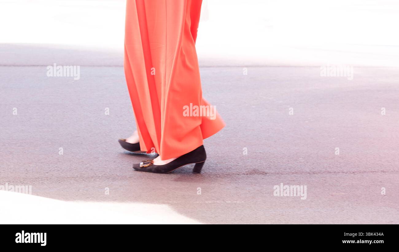 Helles Outfit mit schwarzen Schuhen in urbaner Umgebung an einem sonnigen Tag Stockfoto