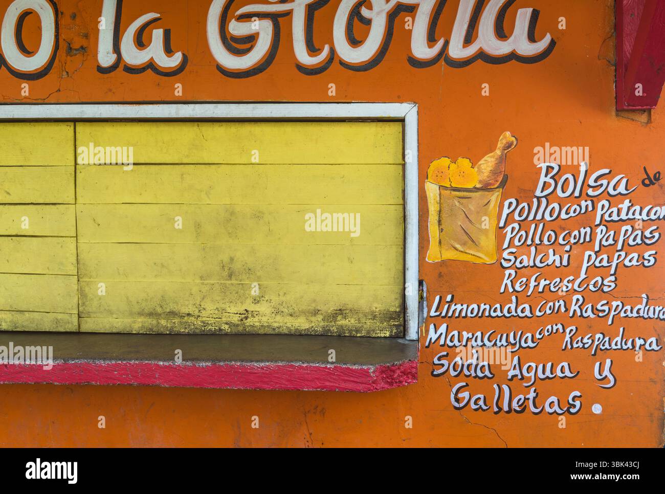 Geschlossene Snackbar mit gelbem Holzverschluss und Werbung auf orangem Hintergrund. Old Bank, Isla Bastimentos, Bocas del Toro, Panama Stockfoto