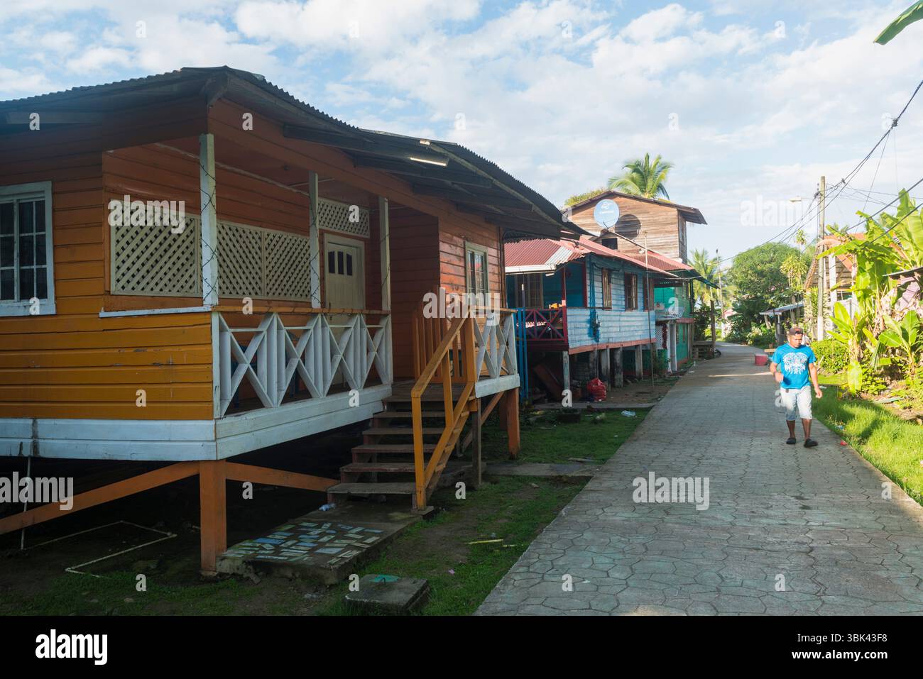 Man spaziert entlang der farbenfrohen Holzpfahlhäuser auf dem Hauptfußweg Old Bank, Isla Bastimentos, Bocas del Toro, Panama Stockfoto