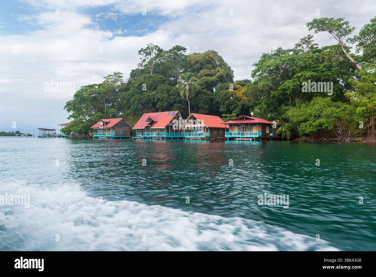 Rustikale Holzpfahlhäuser über dem Wasser entlang des Ufers von Loma Partida, Provinz Bocas del Toro, Panama. Stockfoto