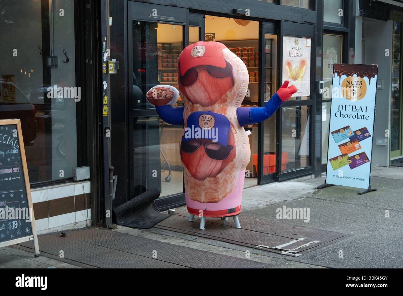 Eine Schaufensterpuppe und ein Schild vor der Nuss Factory, einem Astoria-Geschäft, das gesunde Snacks und Dubai-Schokolade verkauft. Stockfoto