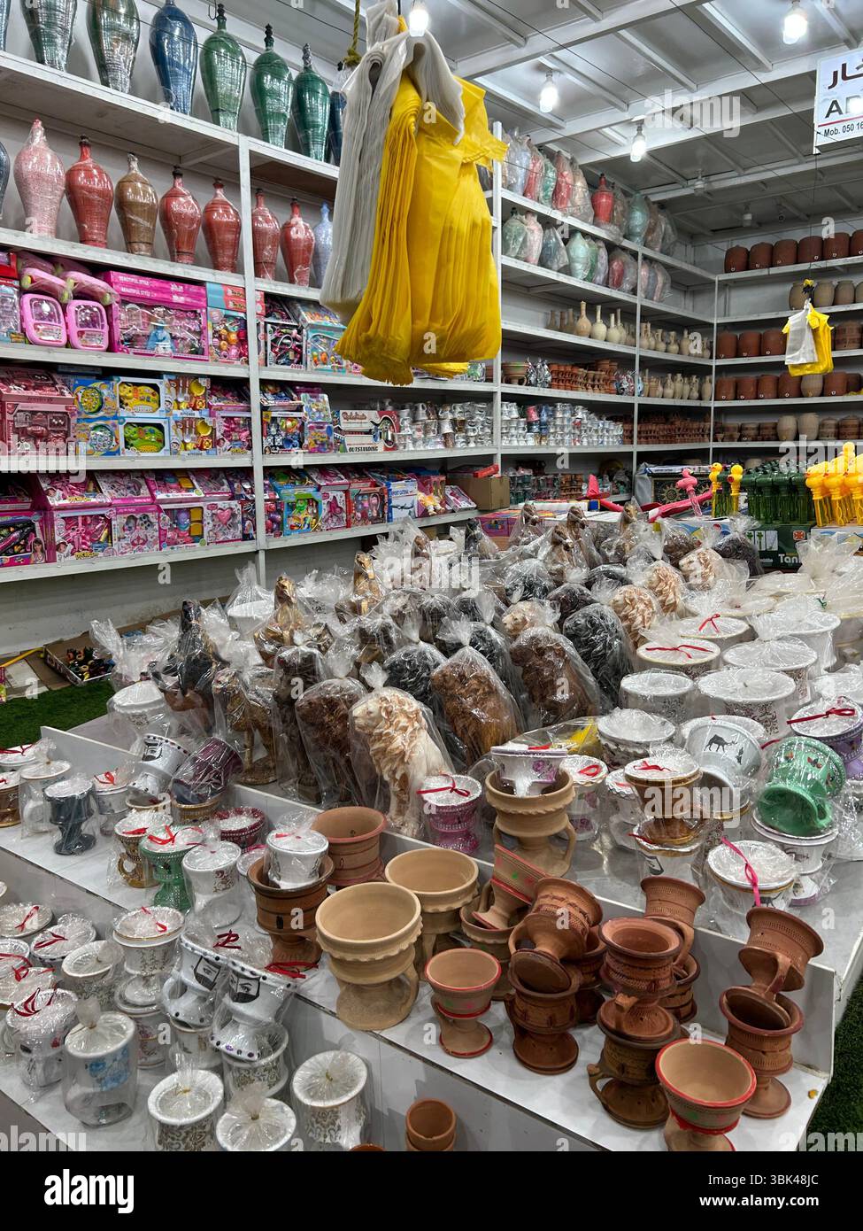 Traditioneller Shop auf dem Masafi Friday Market, VAE, mit einer Auswahl an Töpferwaren, Spielzeug und lokalem Kunsthandwerk in einem Open-Air-Markt. - Smartphone-aufgenommenes Stockfoto