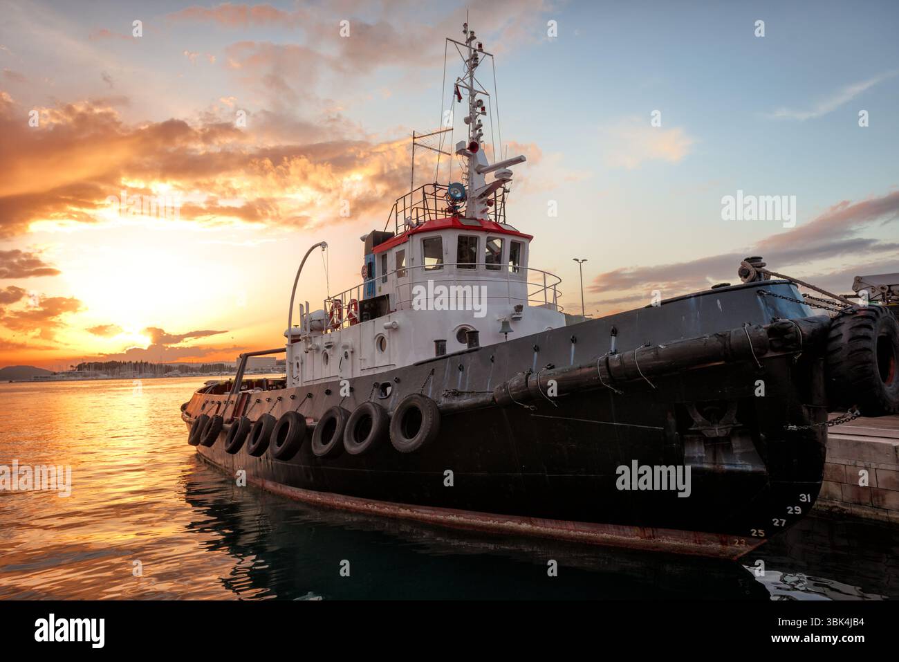 Fischerboot im Ozean bei Sonnenaufgang vor Sonnenuntergang Stockfoto
