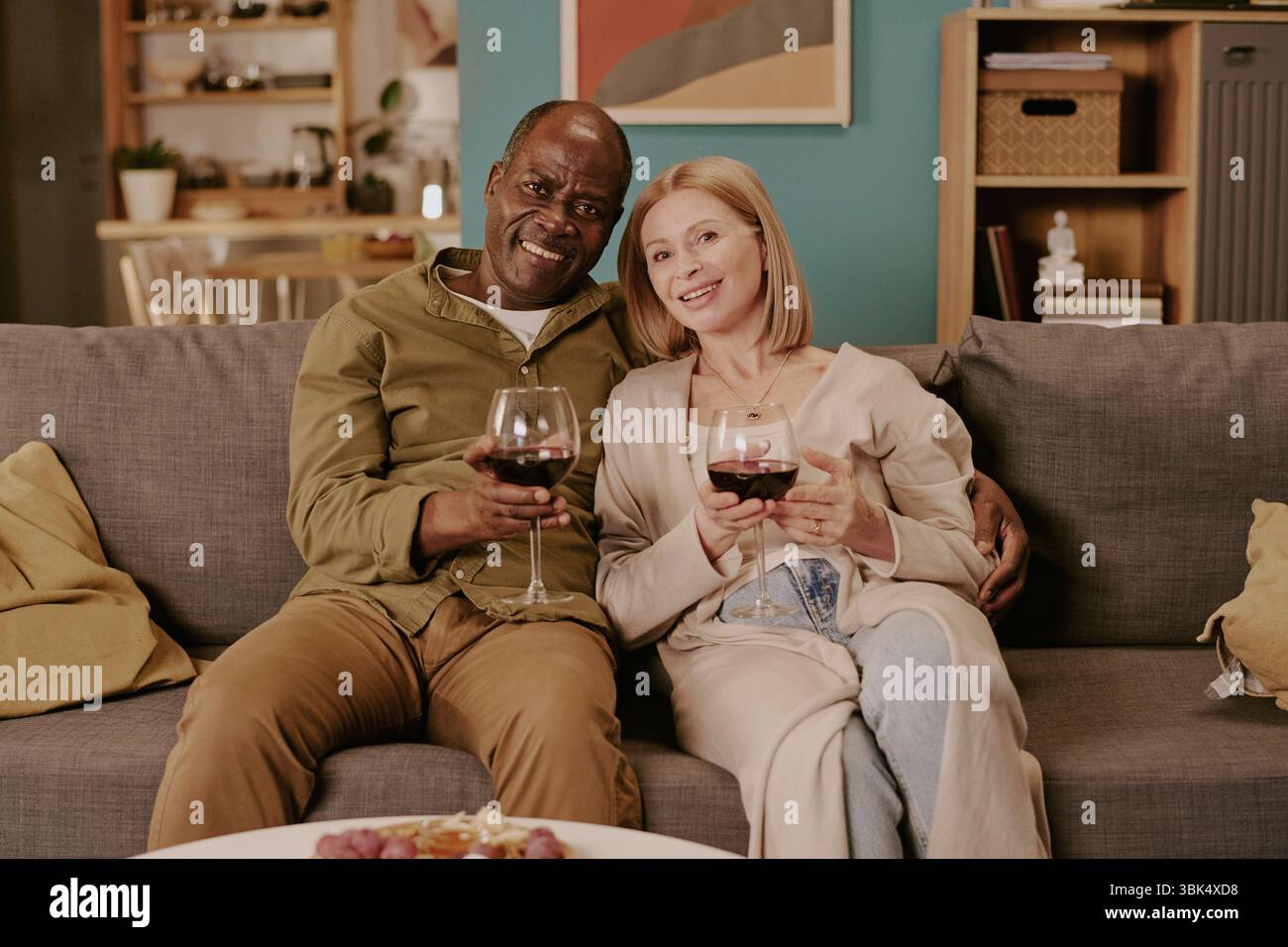 Ältere Multiethnische Paare Sitzen Zusammen Und Genießen Einen Romantischen Abend Drinnen Stockfoto