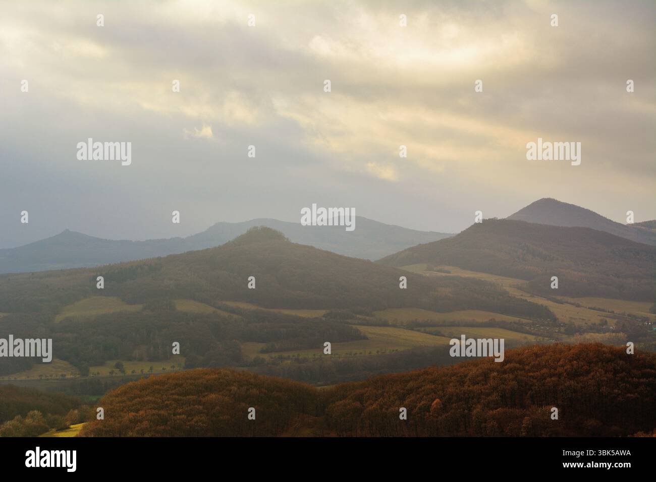 Offene Hügellandschaft unter unvorhersehbaren Wolkenschichten und wechselndem Sonnenschein Stockfoto