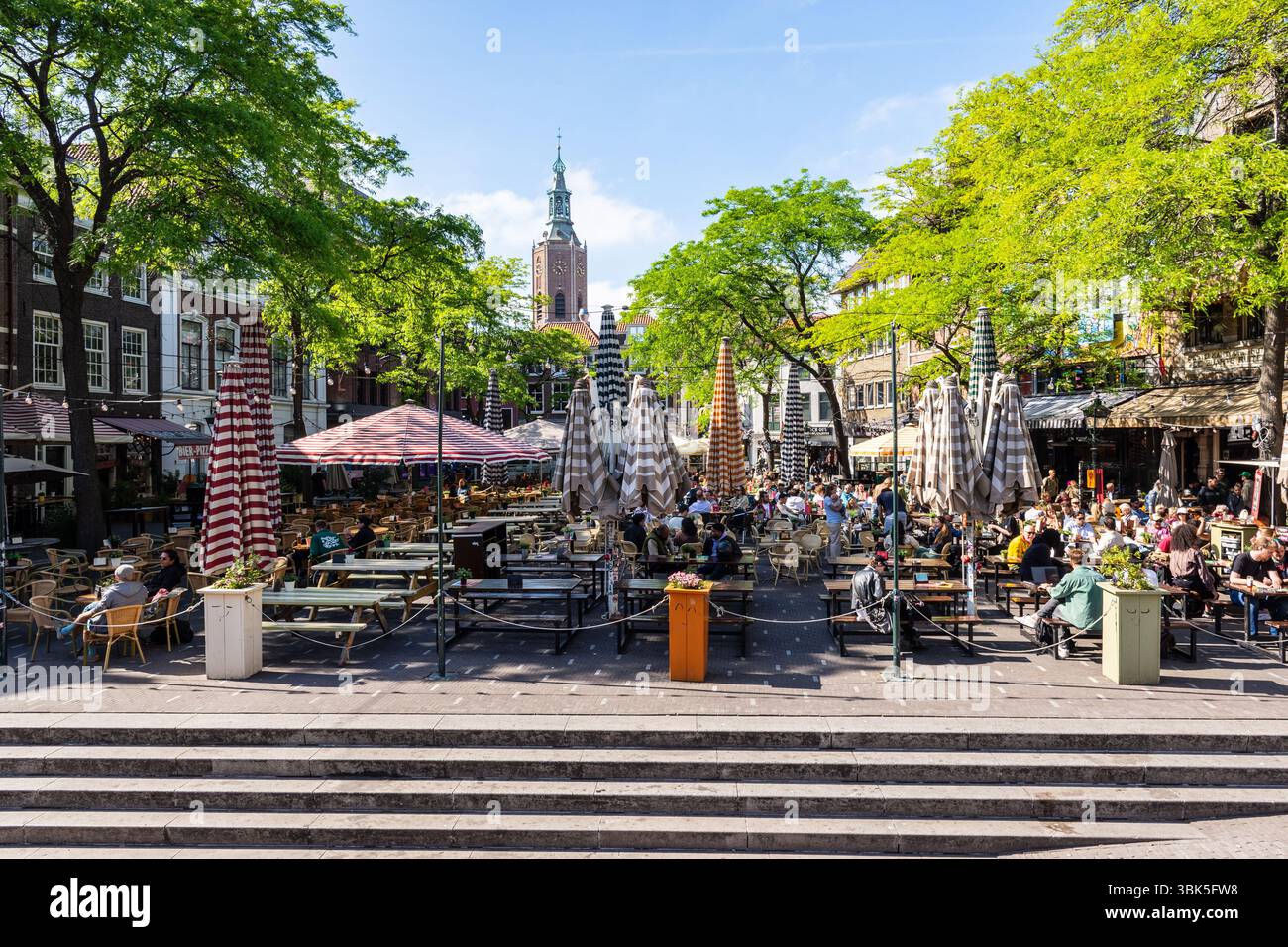 Der Grote Markt in den Haag, Niederlande, wo die Menschen die Straßencafés genießen, mit dem Kirchturm St. James's Church in der Ferne. Stockfoto
