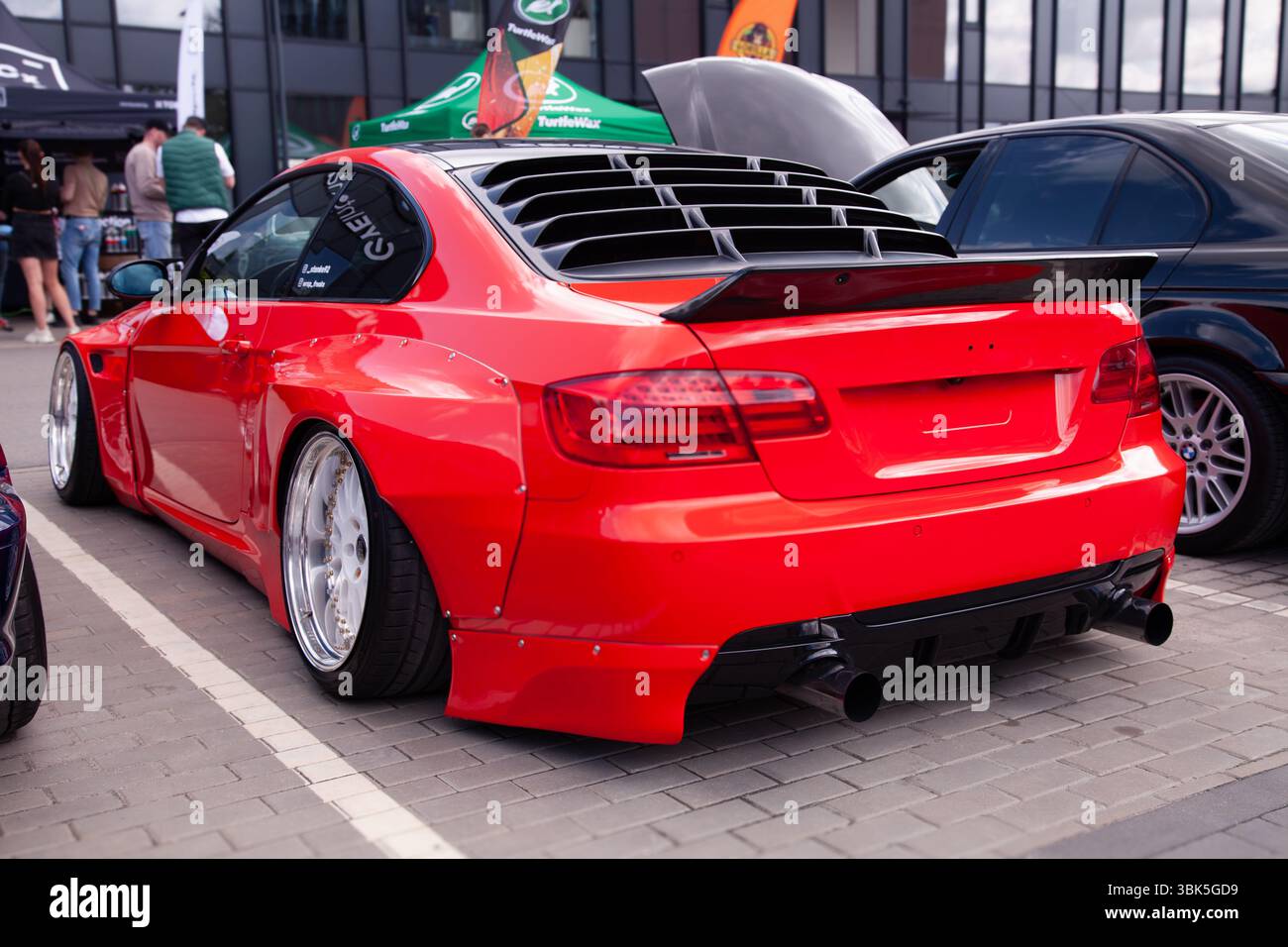 Vilnius, Litauen - 31 05.05.2025 - Rückansicht des roten BMW 3er-Modells mit abgesenktem kundenspezifischem Karosseriesatz, aggressivem negativem Sturz und verchromten Felgen mit tiefen Lippen Stockfoto