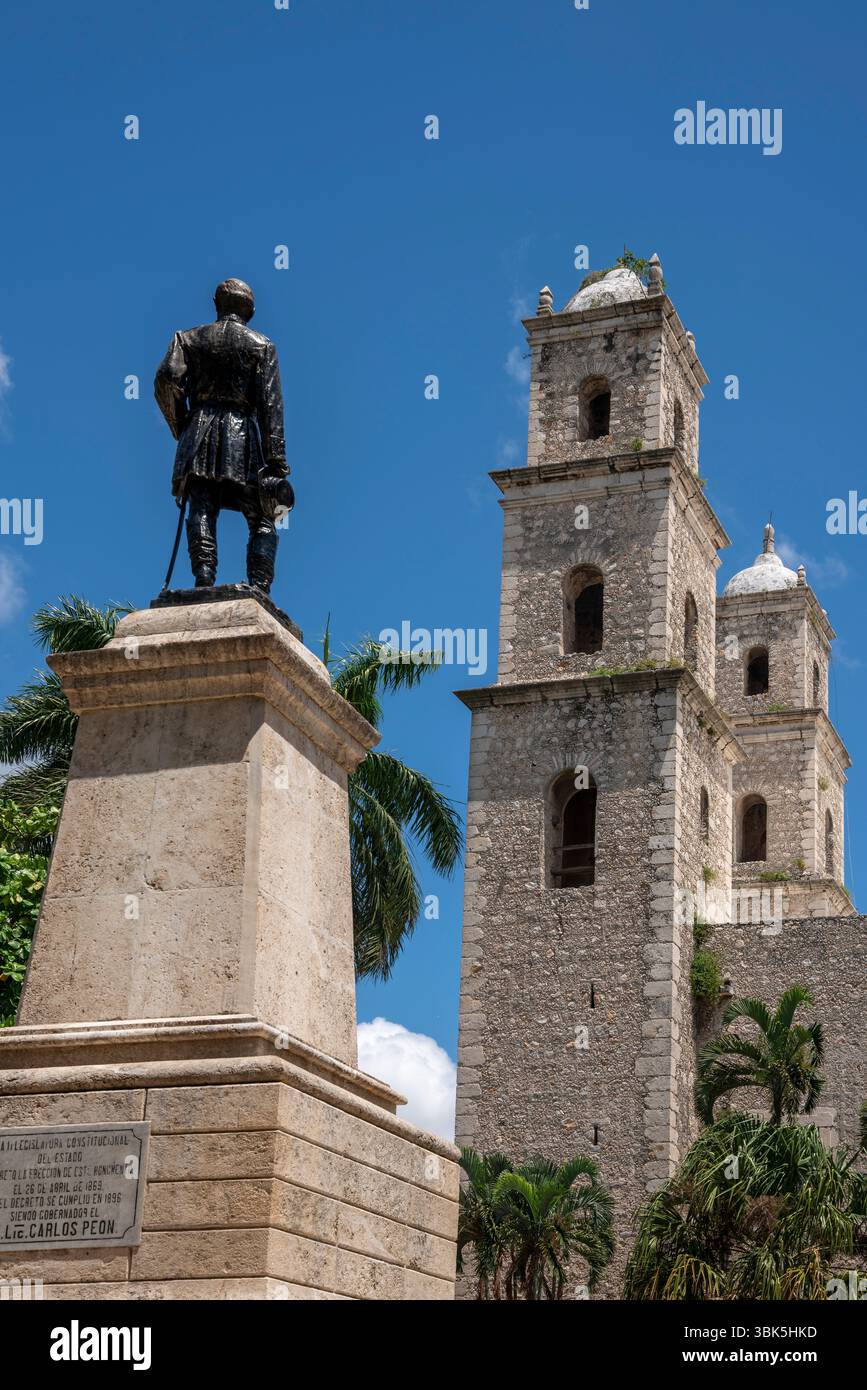 Denkmal-Statue mit Kirche Jesu Zwillingstürme und Palmen in Mexiko, Yucatan Halbinsel, Merida Hidalgo Park. Stockfoto
