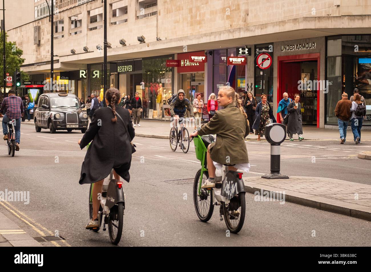 LONDON, 22. MAI 2025: Junge Menschen, die Fahrräder auf der Oxford Street im Londoner West End ausleihen Stockfoto