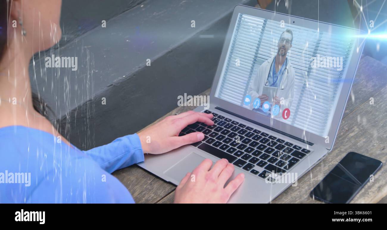 Sprechender Mann mit blauem Hemd, der im Heimbüro einen Laptop benutzt, mit Smartphone auf dem Schreibtisch, Kopierraum Stockfoto