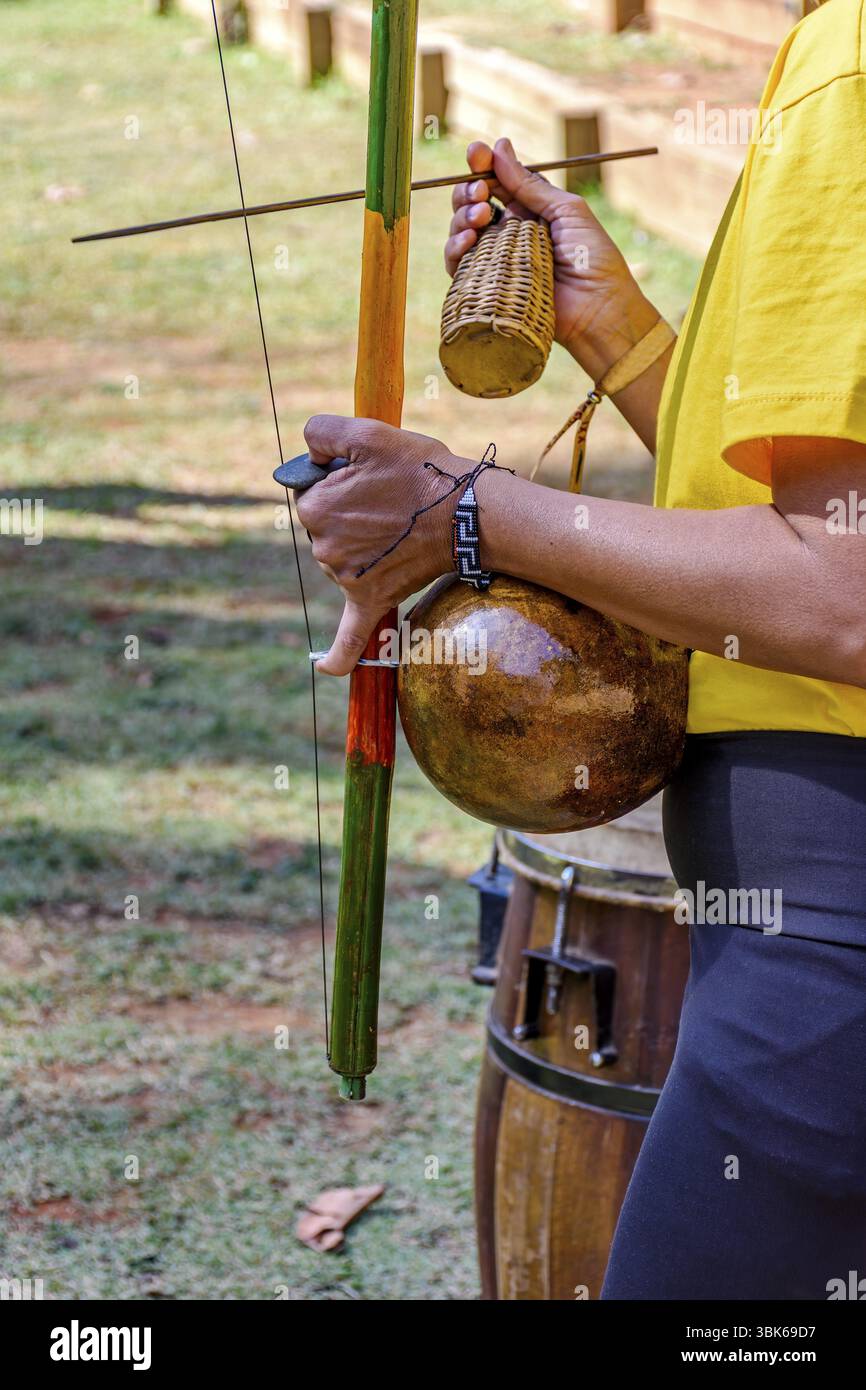Frau spielt ein Instrument afrikanischer Herkunft namens Berimbau im Freien, Minas Gerais, Brasilien, Südamerika Stockfoto