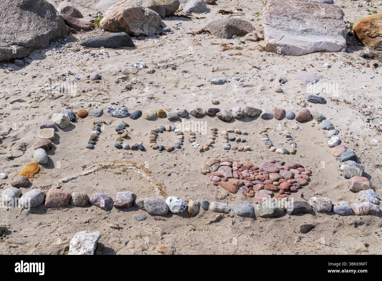 Ich liebe dich mit Herz am Strand mit Steinen im Sand Stockfoto