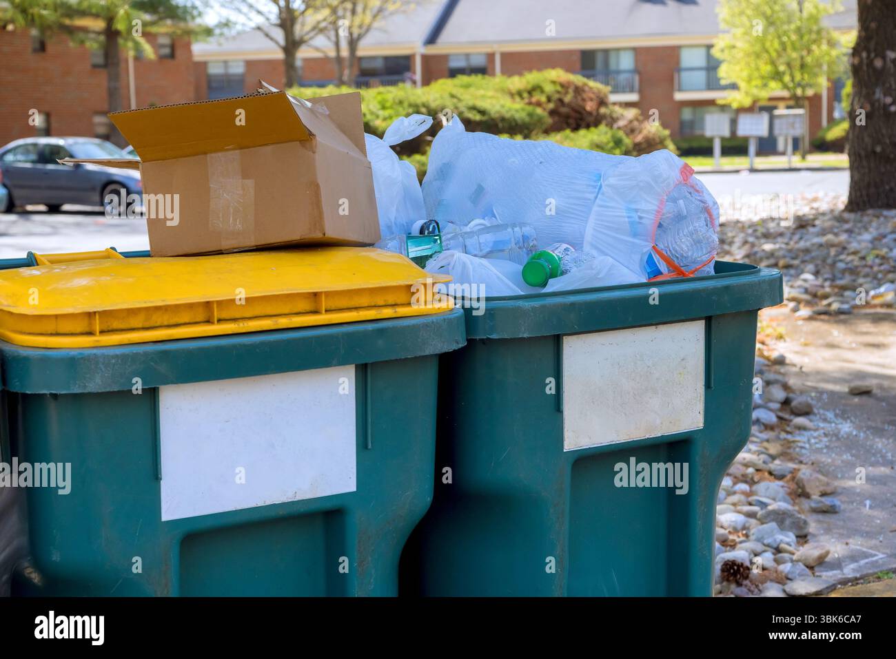 Müll wird am Werktag in zwei Abfallbehältern vor einem Wohngebäude hoch gestapelt Stockfoto