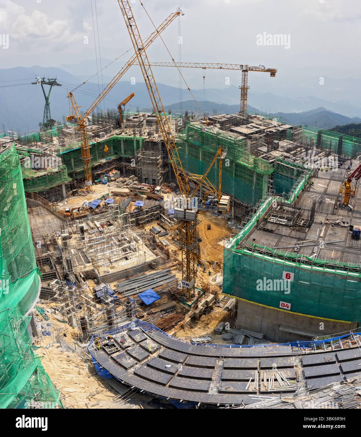BA NA HILLS, VIETNAM, 25. April 2025, große Baustelle mit Kranen und Gebäuden in einer Berglandschaft Stockfoto