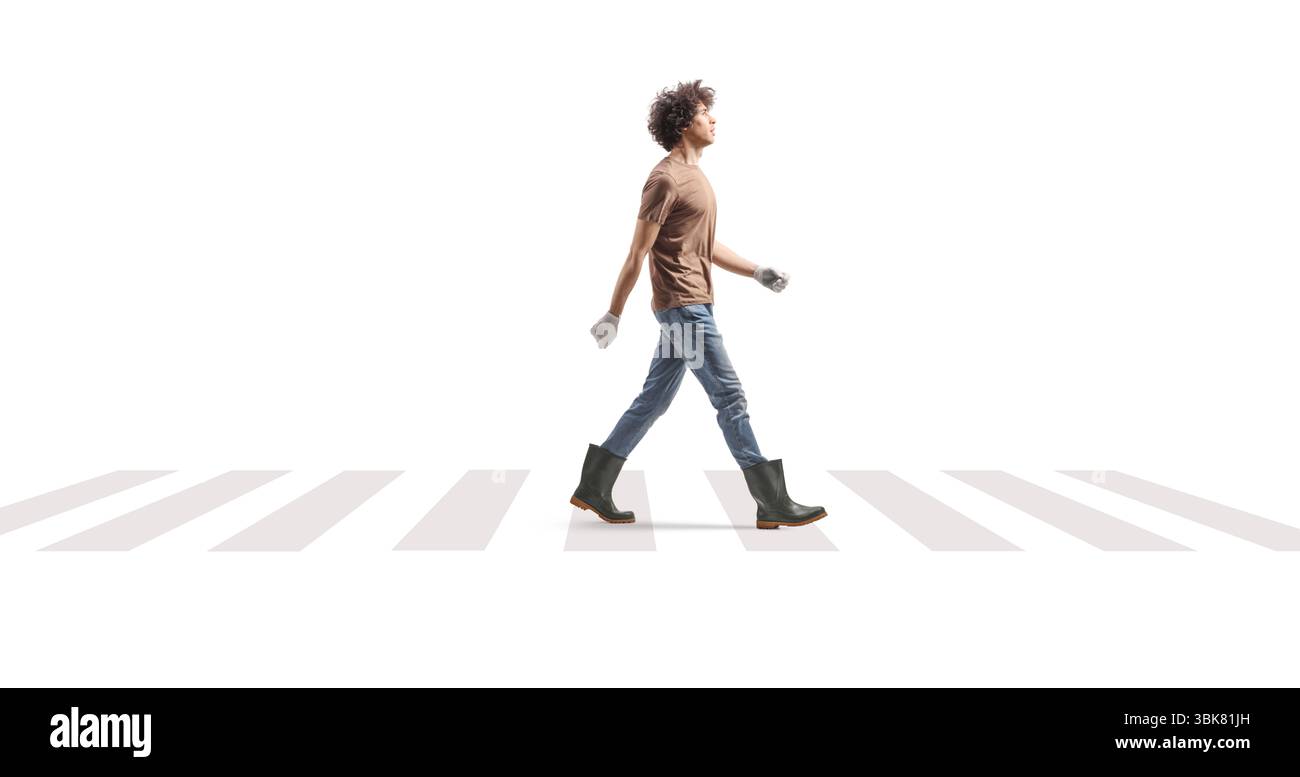 Bauer in Gummistiefeln, der an einem Fußgängerzebra auf weißem Hintergrund vorbeifährt Stockfoto