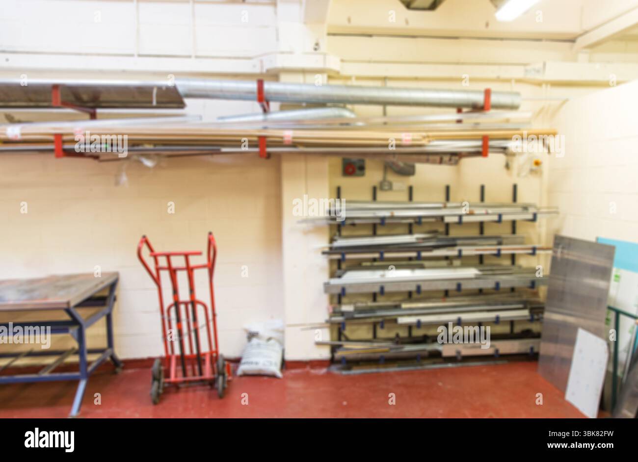 Die flache Abbildung zeigt die Werkstattlagerung mit rotem Handwagen, blauem Tisch und Metallregal Stockfoto