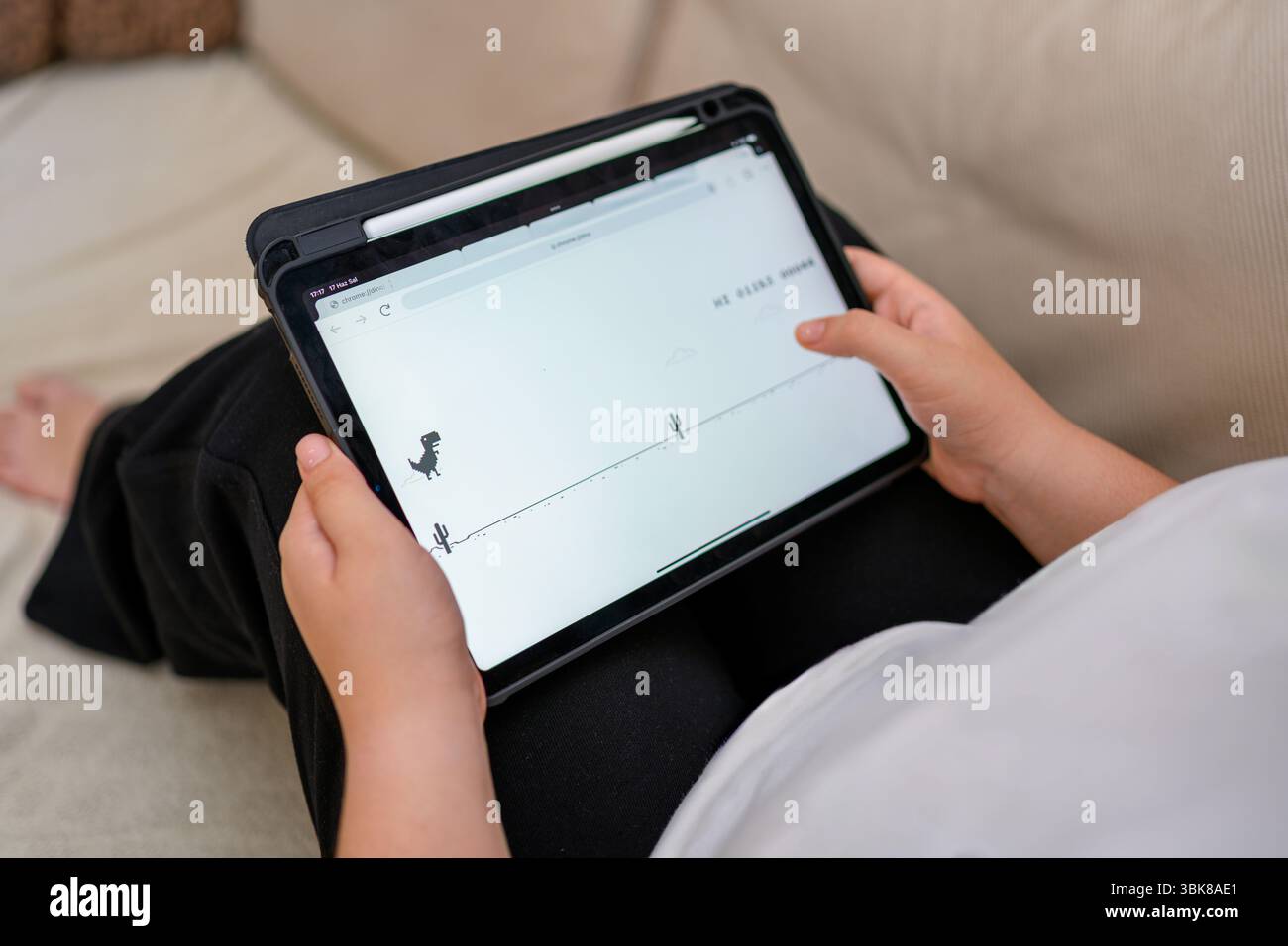 Antalya, Türkei - 17. Juni 2025: Mädchen spielt Chrome Dino Laufspiel Stockfoto