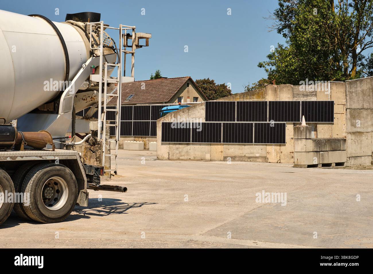 14. Juni 2025 - Benz-Deutschland: Solarpaneele, die vertikal an Betonspeicherwänden auf einem Betonwerksstandort installiert werden, veranschaulichen nachhaltige Energie uns Stockfoto