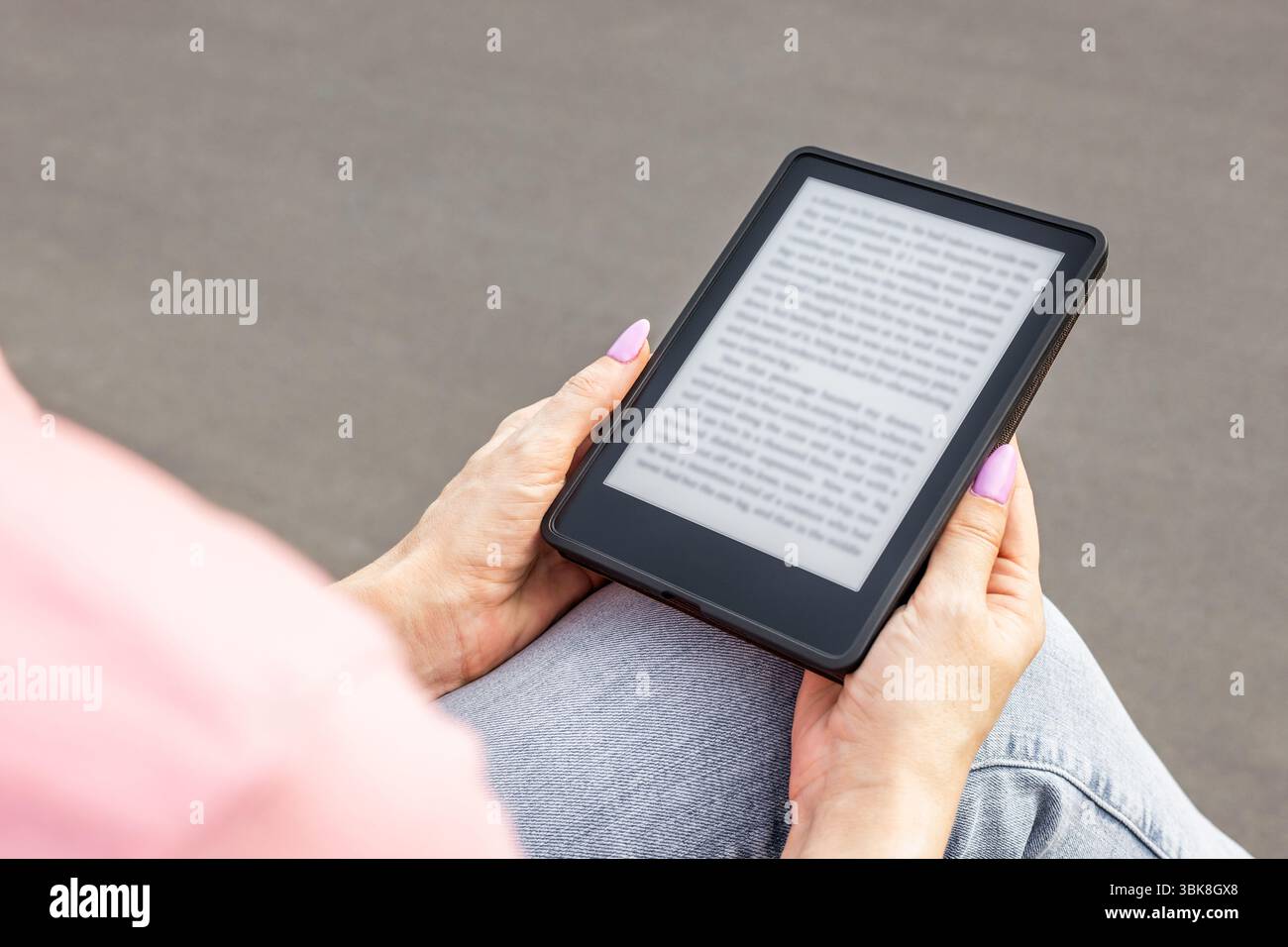 Frau, die E-Book liest, sitzt auf der Bank, Nahaufnahme. Stockfoto