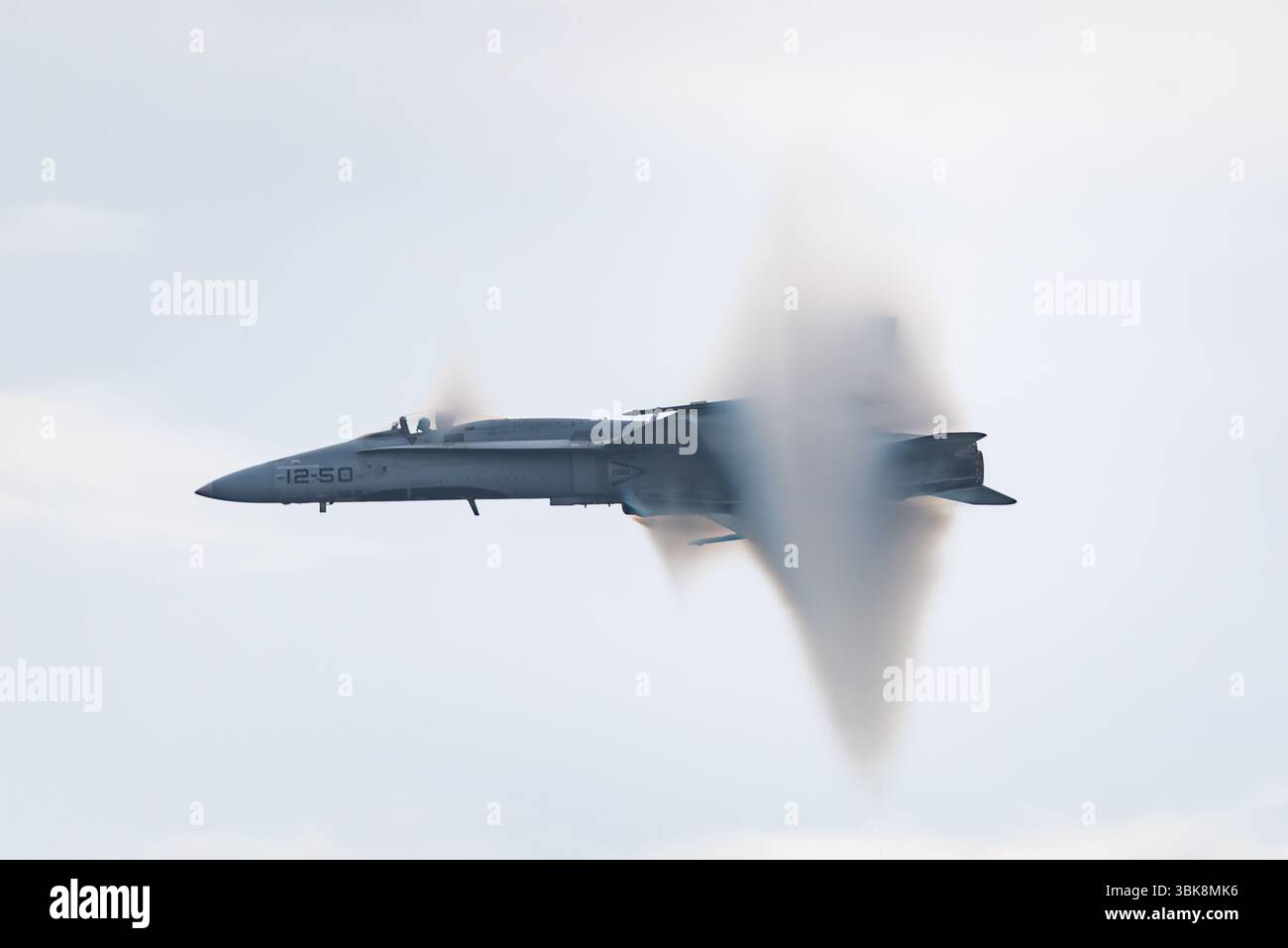 Die spanische Luftwaffe McDonnell Douglas EF-18A Hornet Jet fliegt schnell beim AIRE25 Air Festival in San Javier, Murcia, Spanien. Stoßkegel Stockfoto