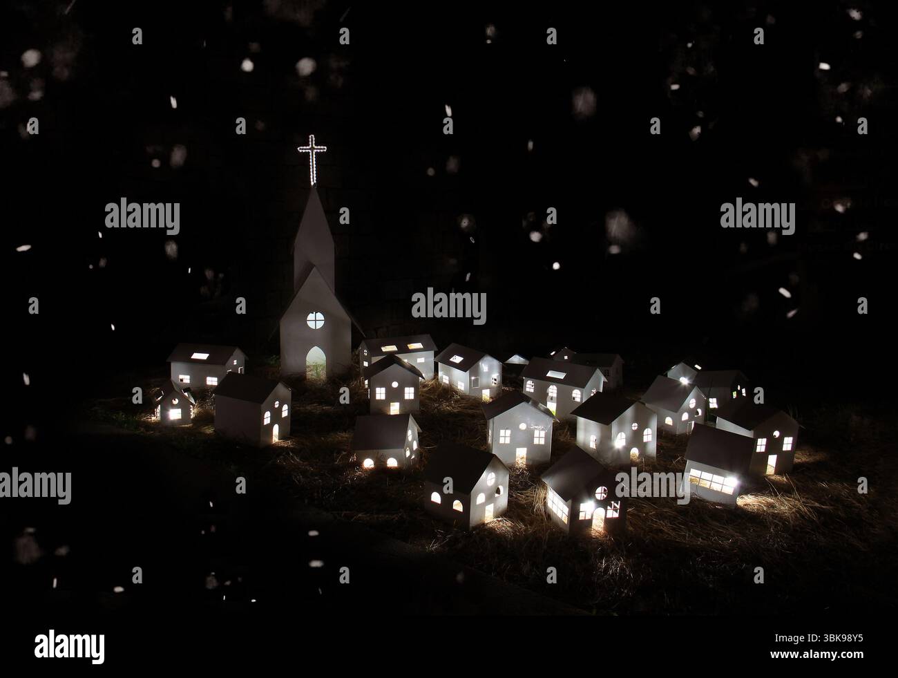 Wundervolle Weihnachtsdörfszene mit leuchtenden Lichtern und fallendem Schnee. Gemütliche, magische Winteratmosphäre mit einem Hauch von Fantasie und Urlaubsstimmung Stockfoto