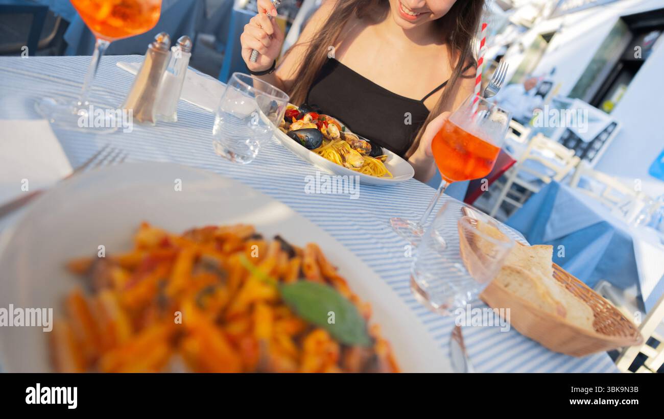 Restauranttisch mit traditionellem italienischem Essen und wunderschöner Nahaufnahme der Frau Stockfoto