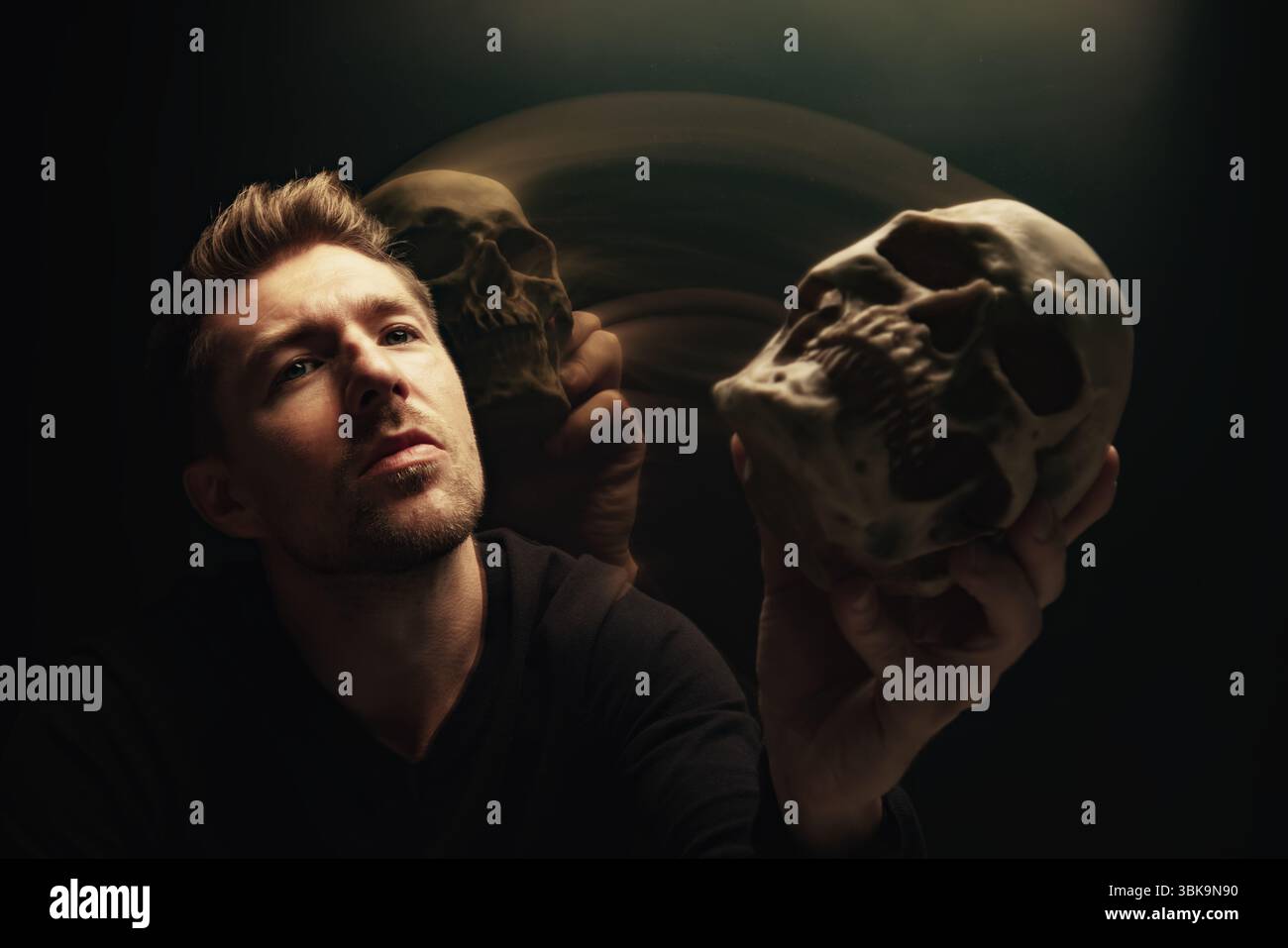 Ein Mann, der den Schädel aushält und ihm ein konzeptionelles Nahaufnahme-Foto anbietet Stockfoto