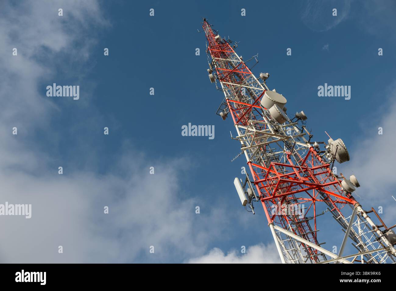 Großer Sendeturm gegen tiefblauen Himmel und Wolkenwinkel Stockfoto