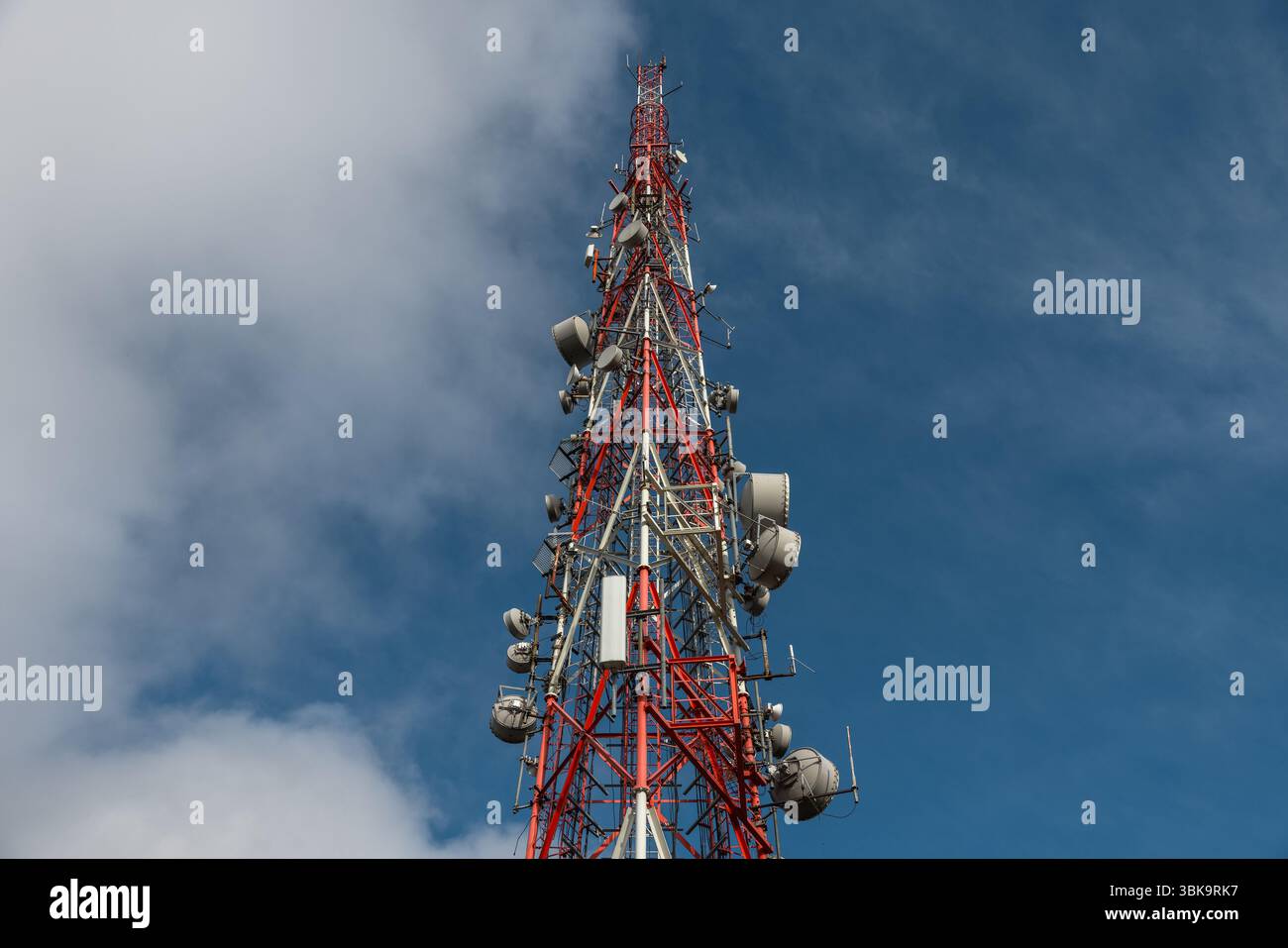 Großer Sendeturm gegen tiefblauen Himmel und Wolkenwinkel Stockfoto