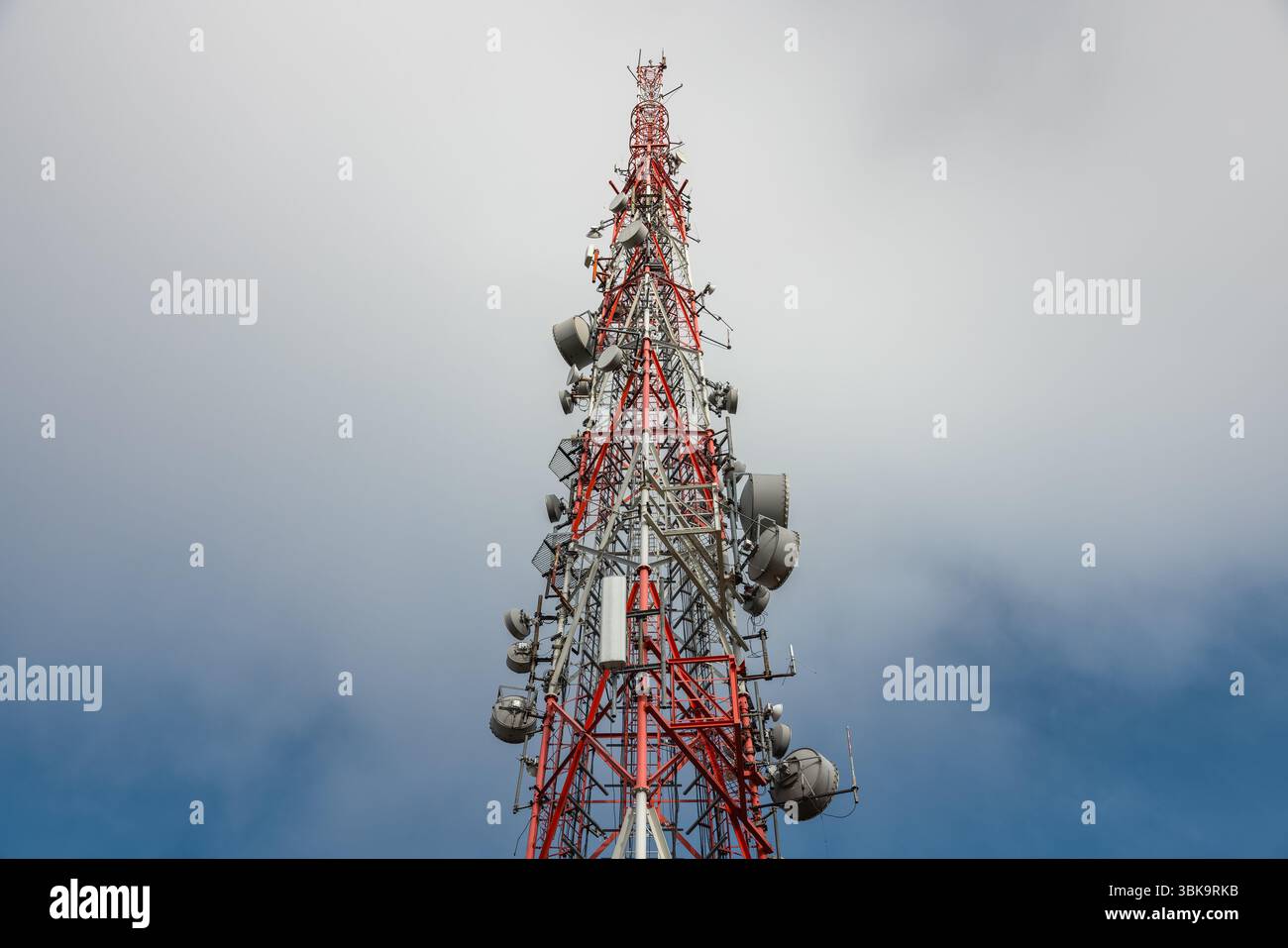 Großer Sendeturm gegen tiefblauen Himmel und Wolkenwinkel Stockfoto