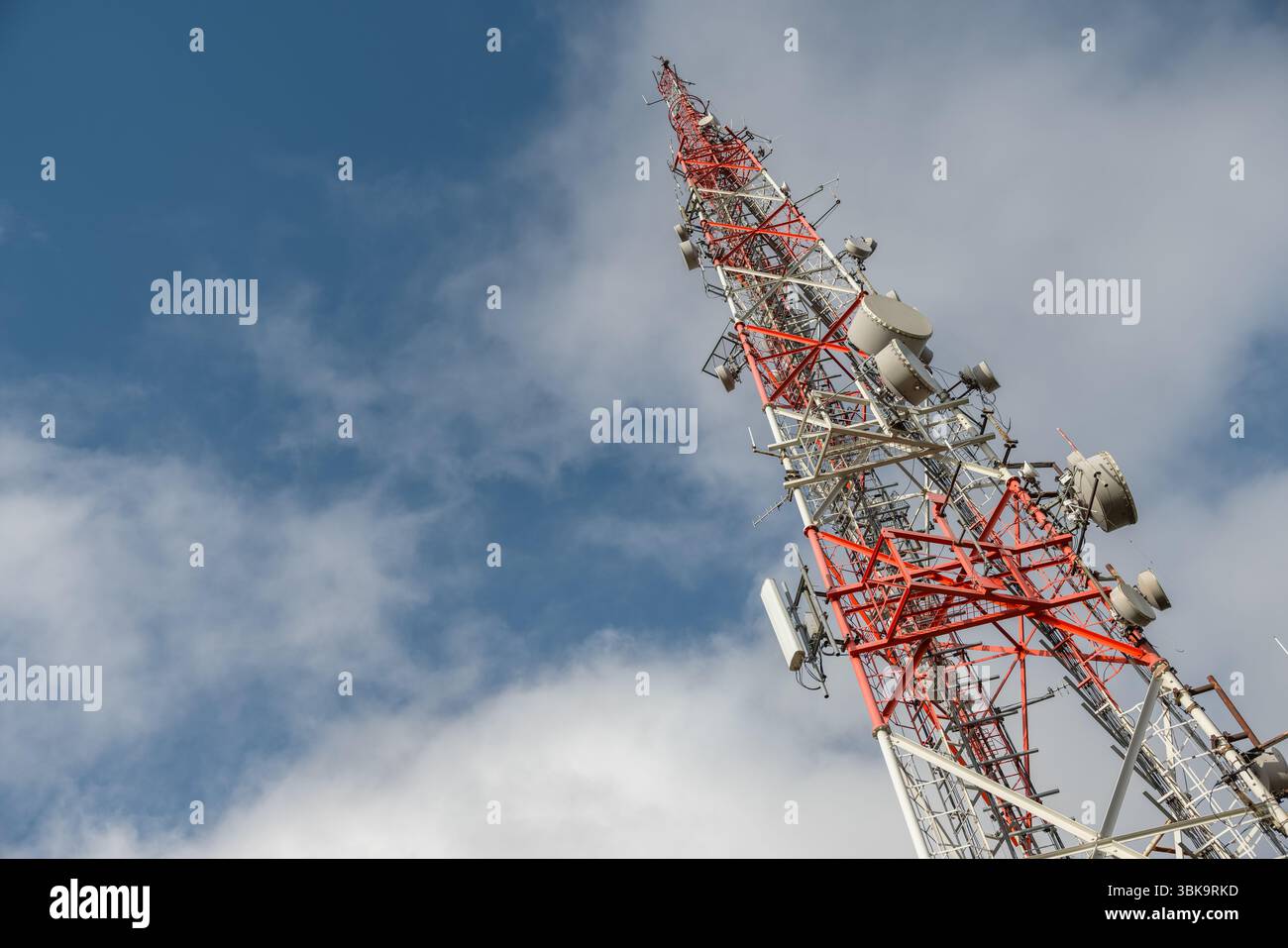 Großer Sendeturm gegen tiefblauen Himmel und Wolkenwinkel Stockfoto