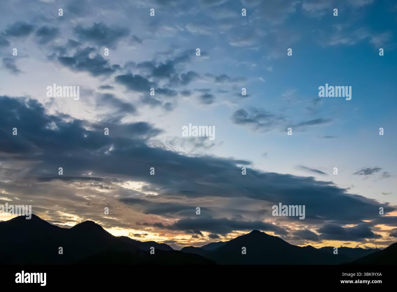Panoramablick auf die Silhouetten der Berge unter dem Morgenhimmel in Pastel Stockfoto