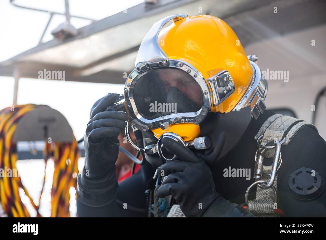 Kommerzieller Taucher, der in der Nähe des Schutzhelms ins Wasser steigt Stockfoto