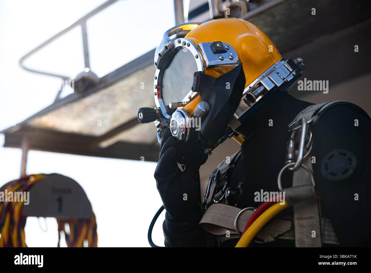 Kommerzieller Taucher, der in der Nähe des Schutzhelms ins Wasser steigt Stockfoto