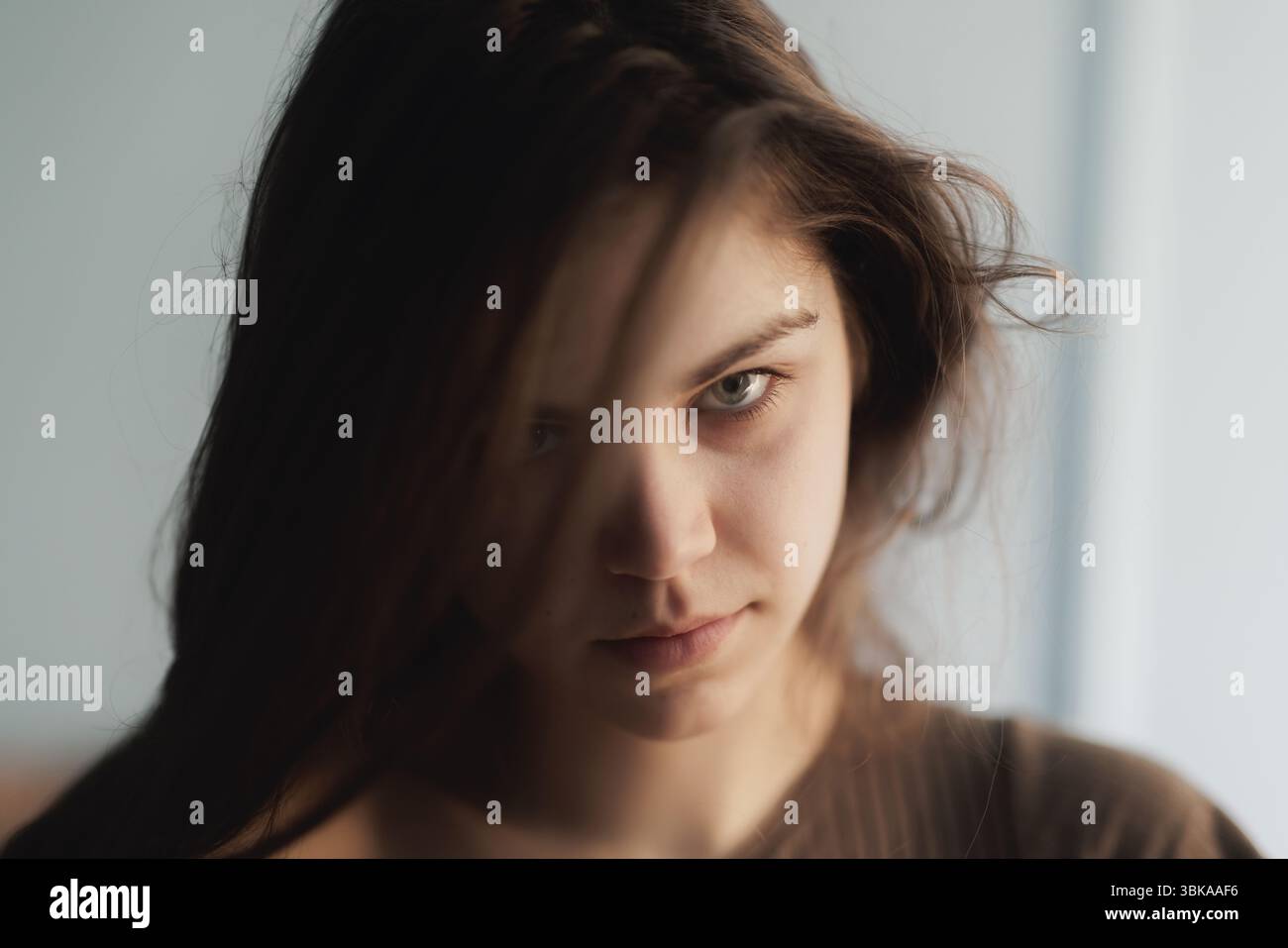 Nachdenkliche junge Frau mit intensiver Nahaufnahme Stockfoto