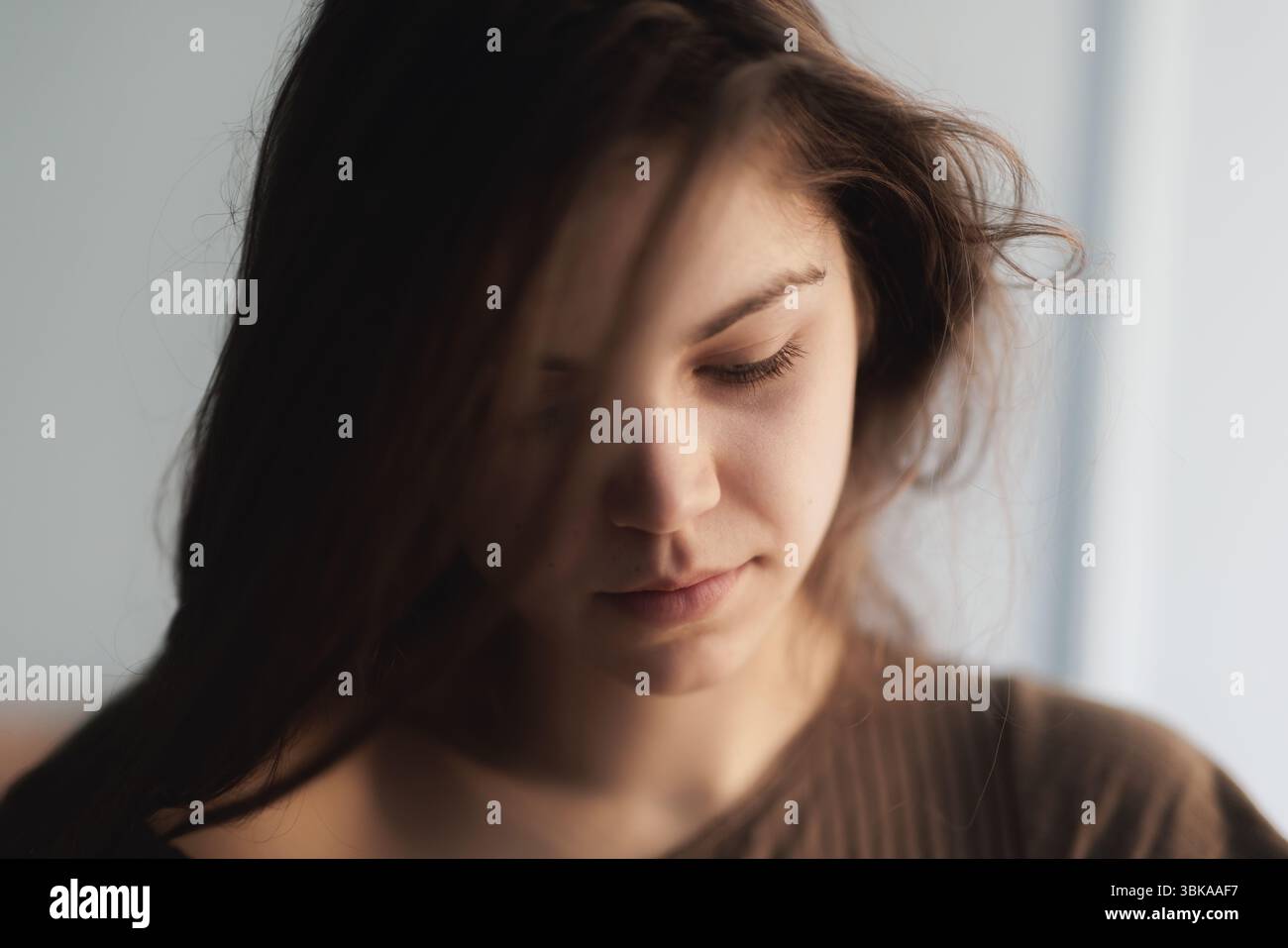 Nachdenkliche junge Frau mit intensiver Nahaufnahme Stockfoto