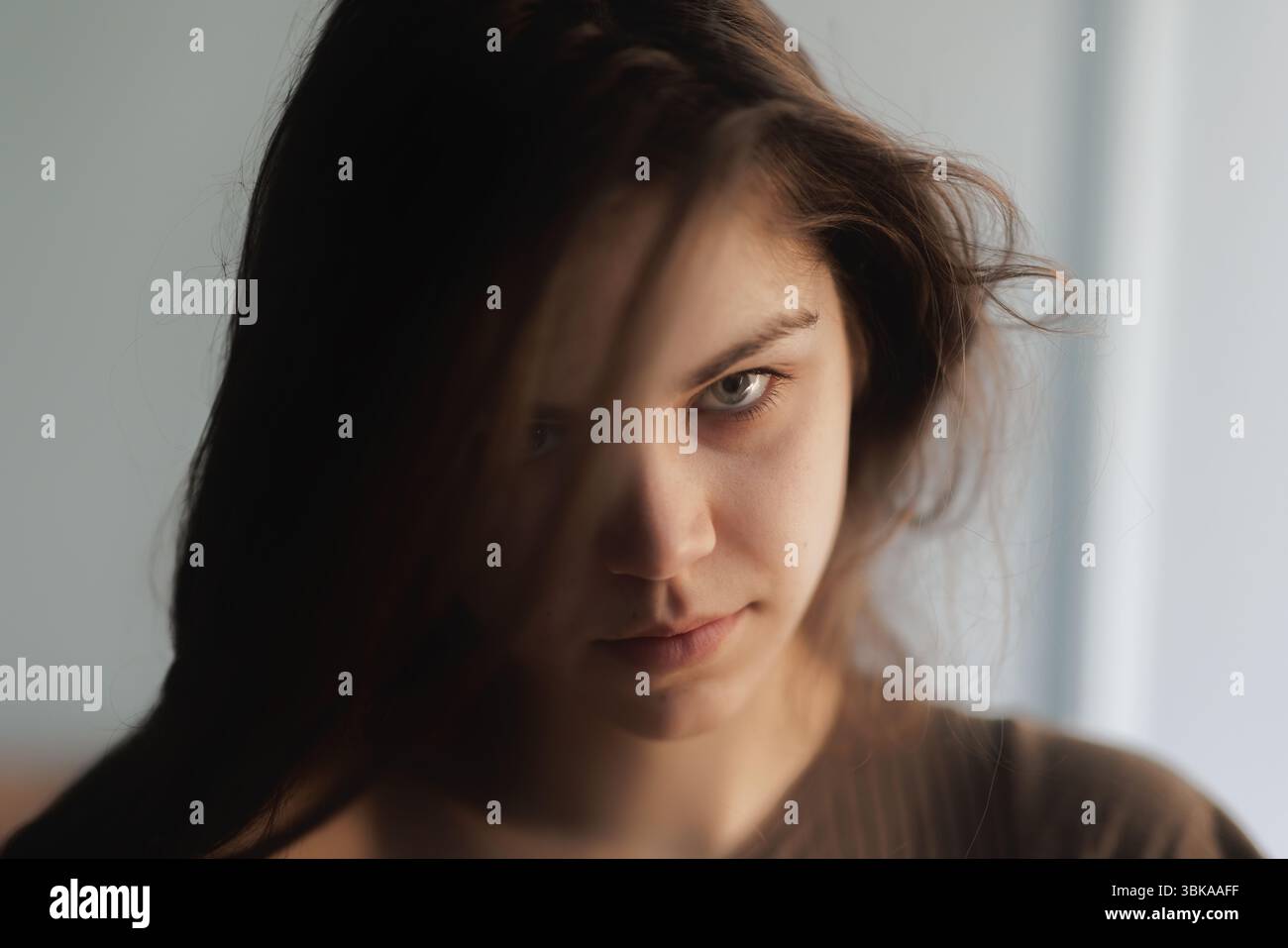 Nachdenkliche junge Frau mit intensiver Nahaufnahme Stockfoto