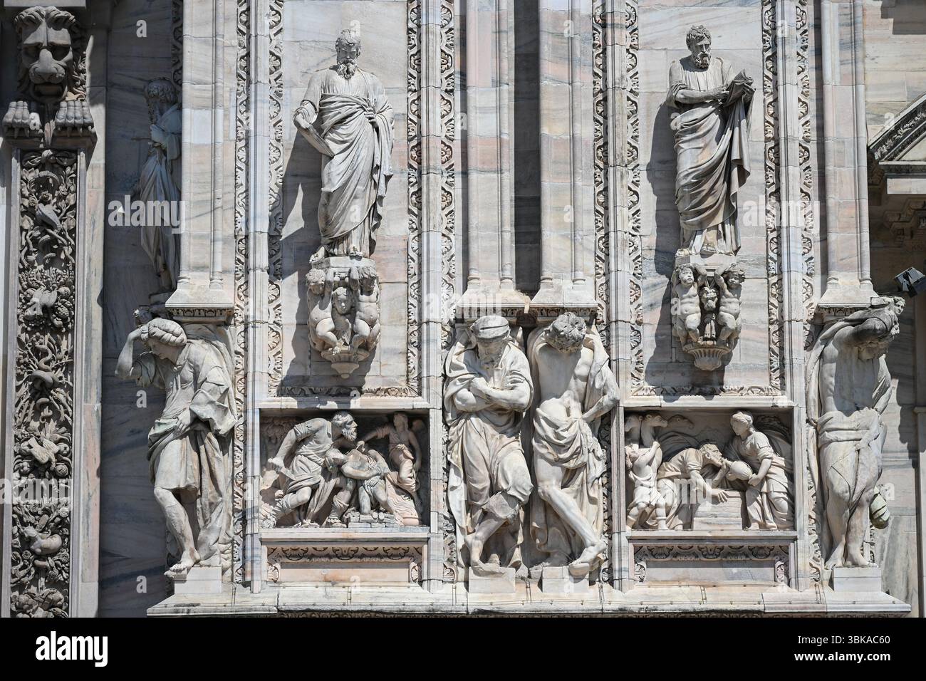 Mailand, Italien: Statuen aus Candoglia-Marmor und Basreliefs an der Fassade des Doms Stockfoto