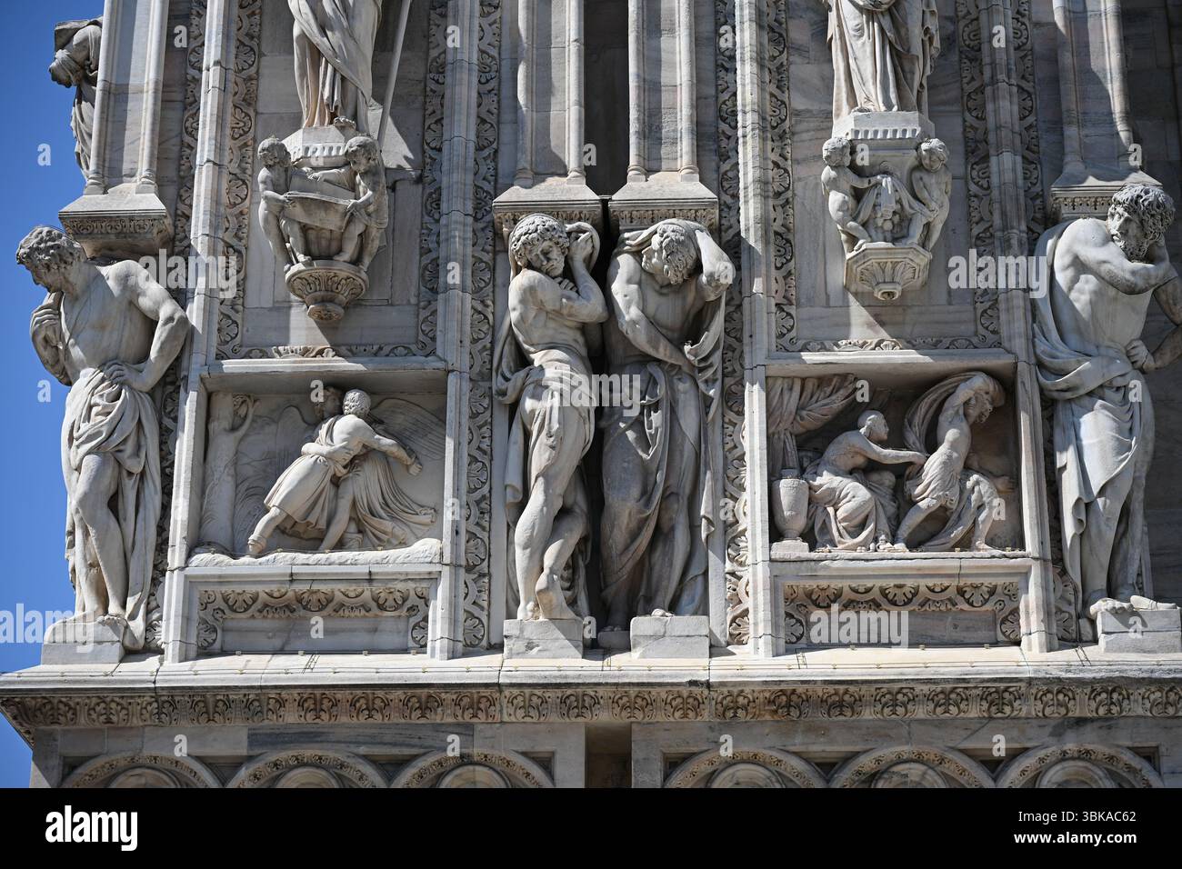 Mailand, Italien: Statuen aus Candoglia-Marmor und Basreliefs an der Fassade des Doms Stockfoto