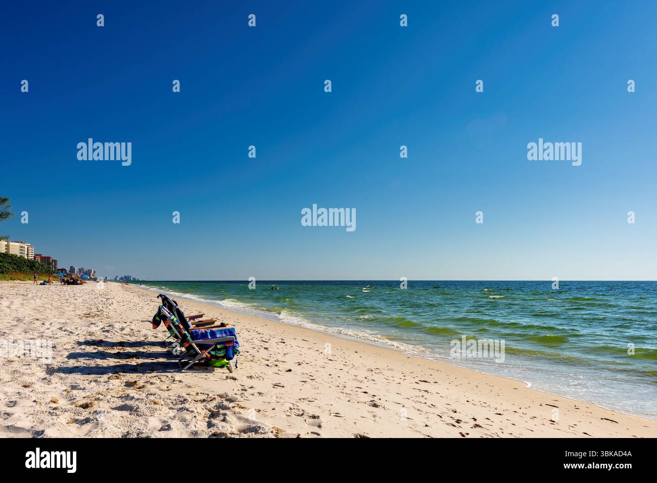 Liegestühle am Sandstrand und türkisfarbenem Meer. Sommerurlaub und Reisekonzept. Stockfoto Liegestühle am Sandstrand und türkisfarbenem Meer. Sommerurlaub und Reisekonzept. Stockfoto